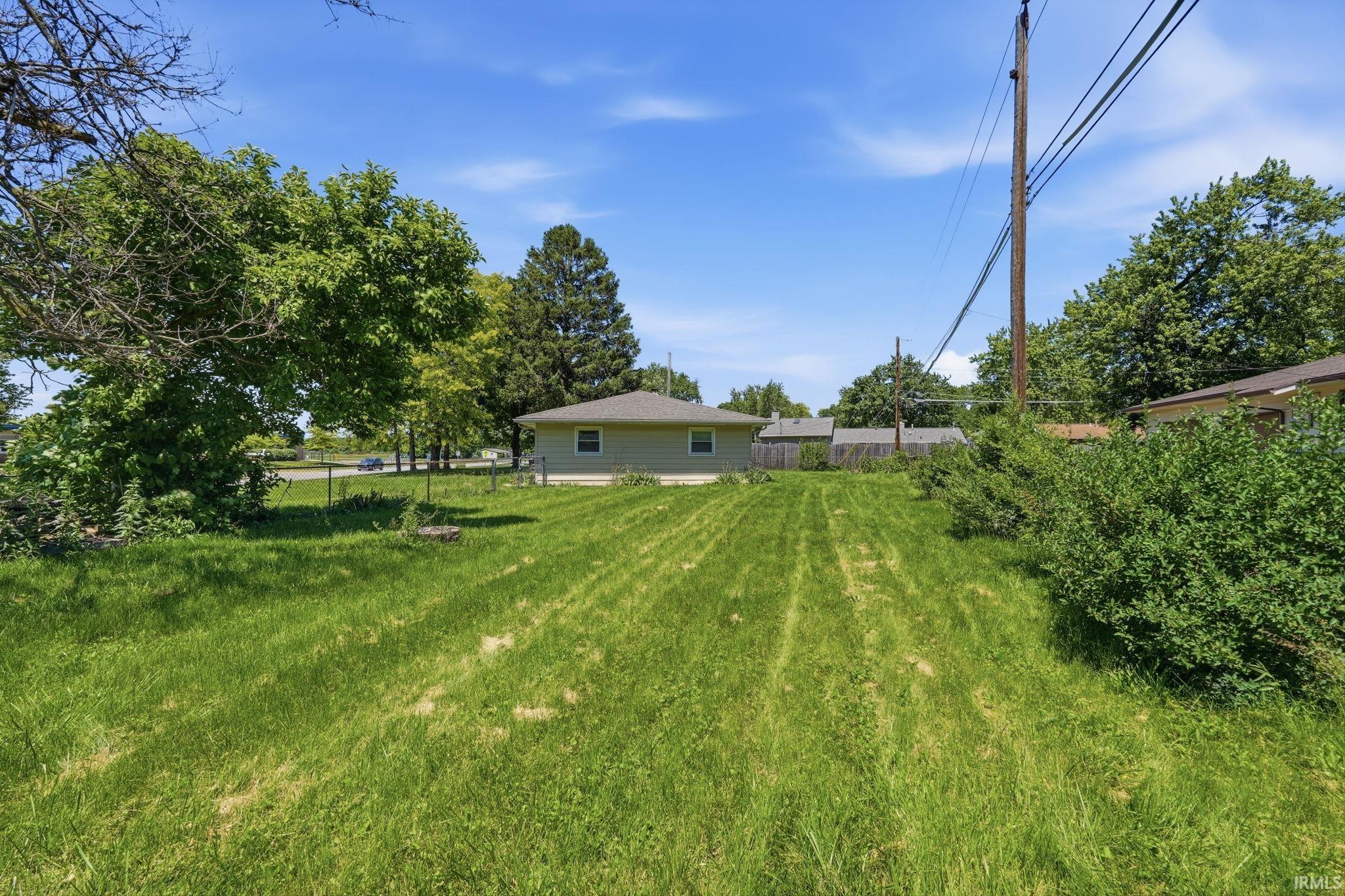 Expansive green lawn with mature trees and established shrubbery
