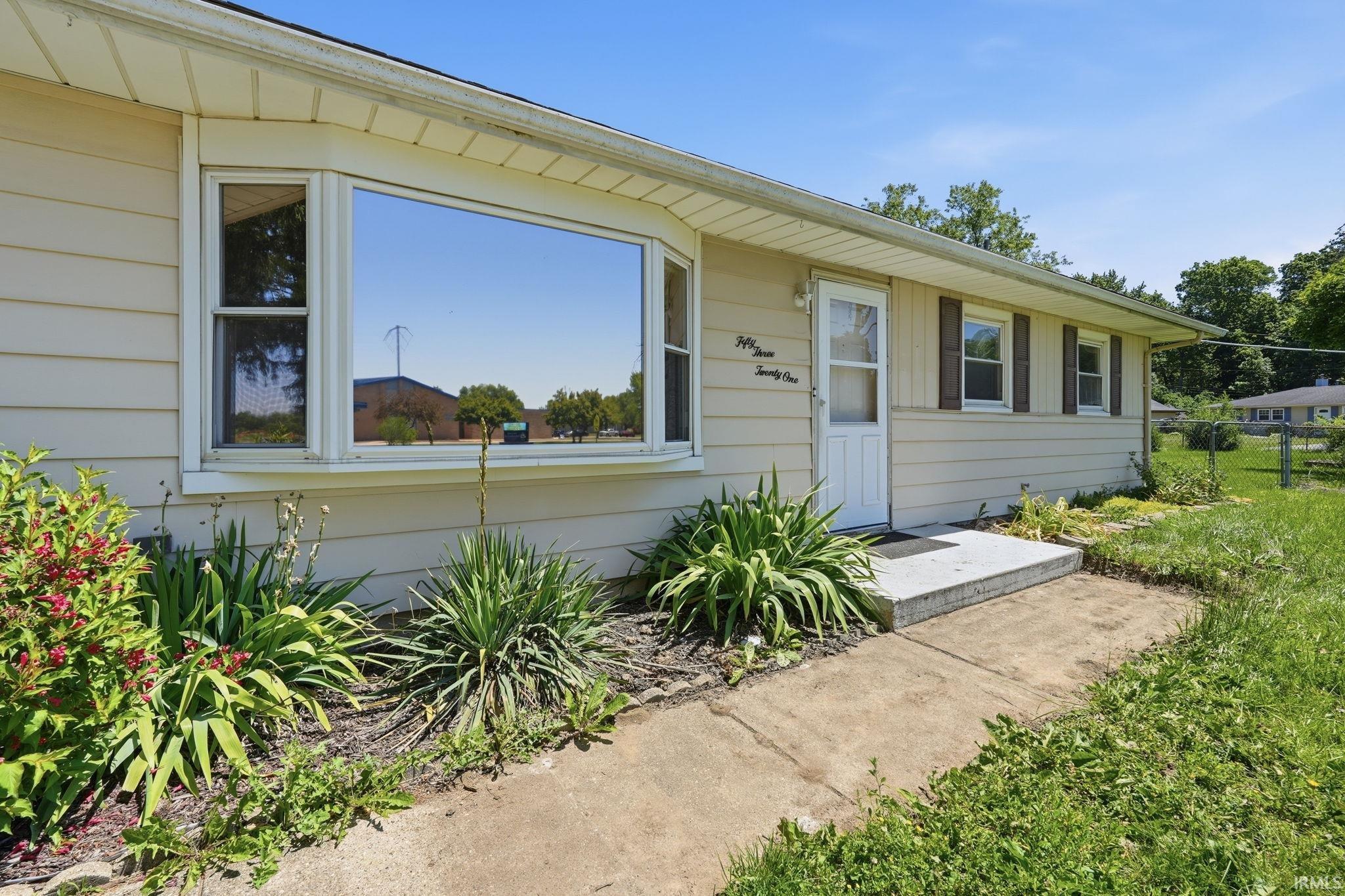 Ranch-style exterior with beige horizontal siding and a large front picture window