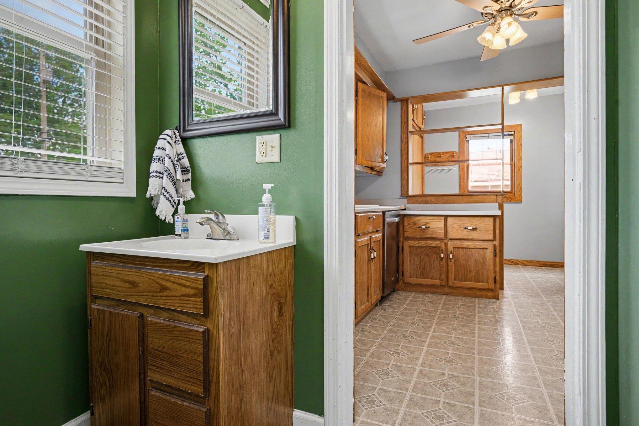 Powder room featuring a single vanity with a white countertop and wood-finish cabinetry