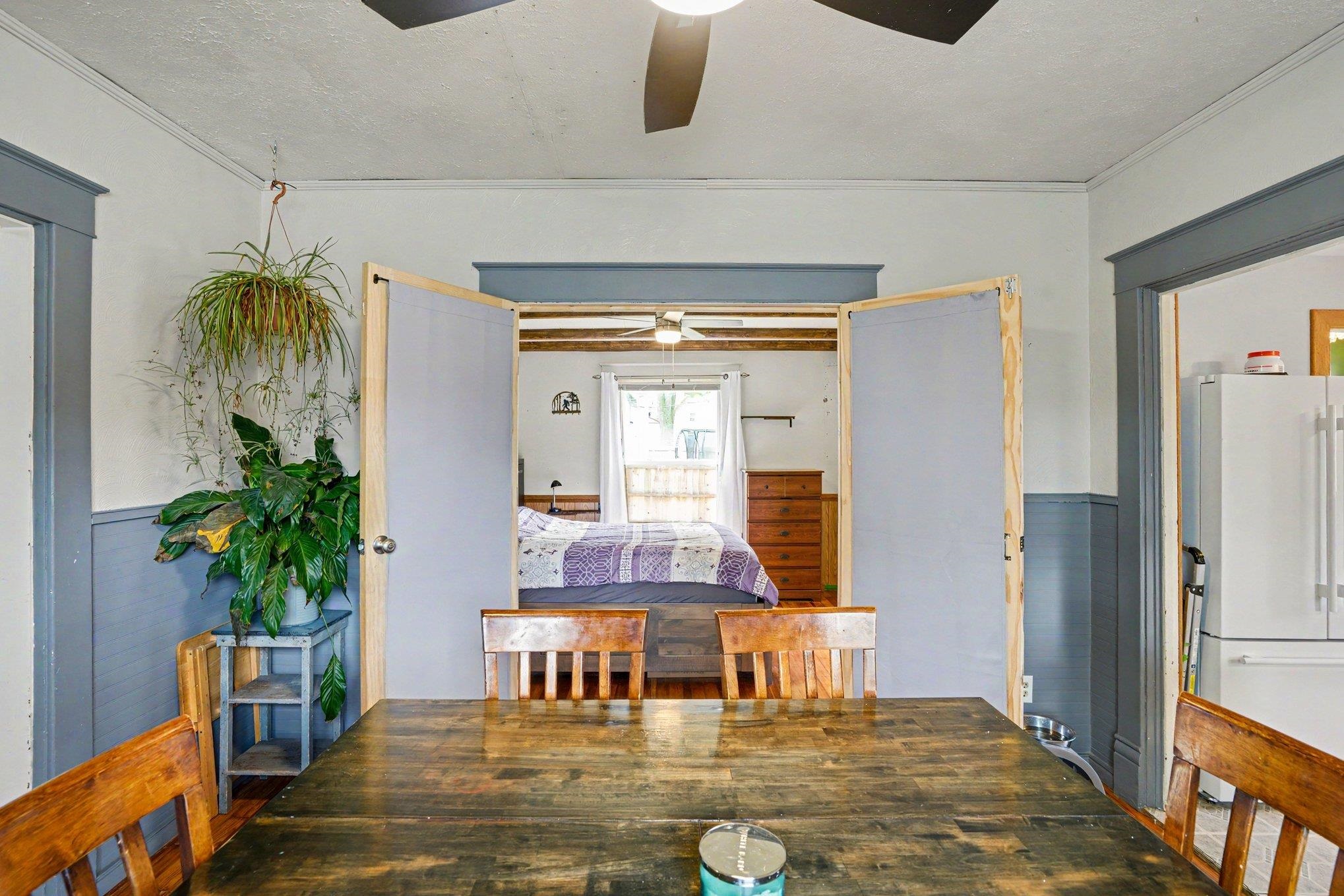 Dining space featuring a wood-finish tabletop, two wood chairs, and a ceiling fan