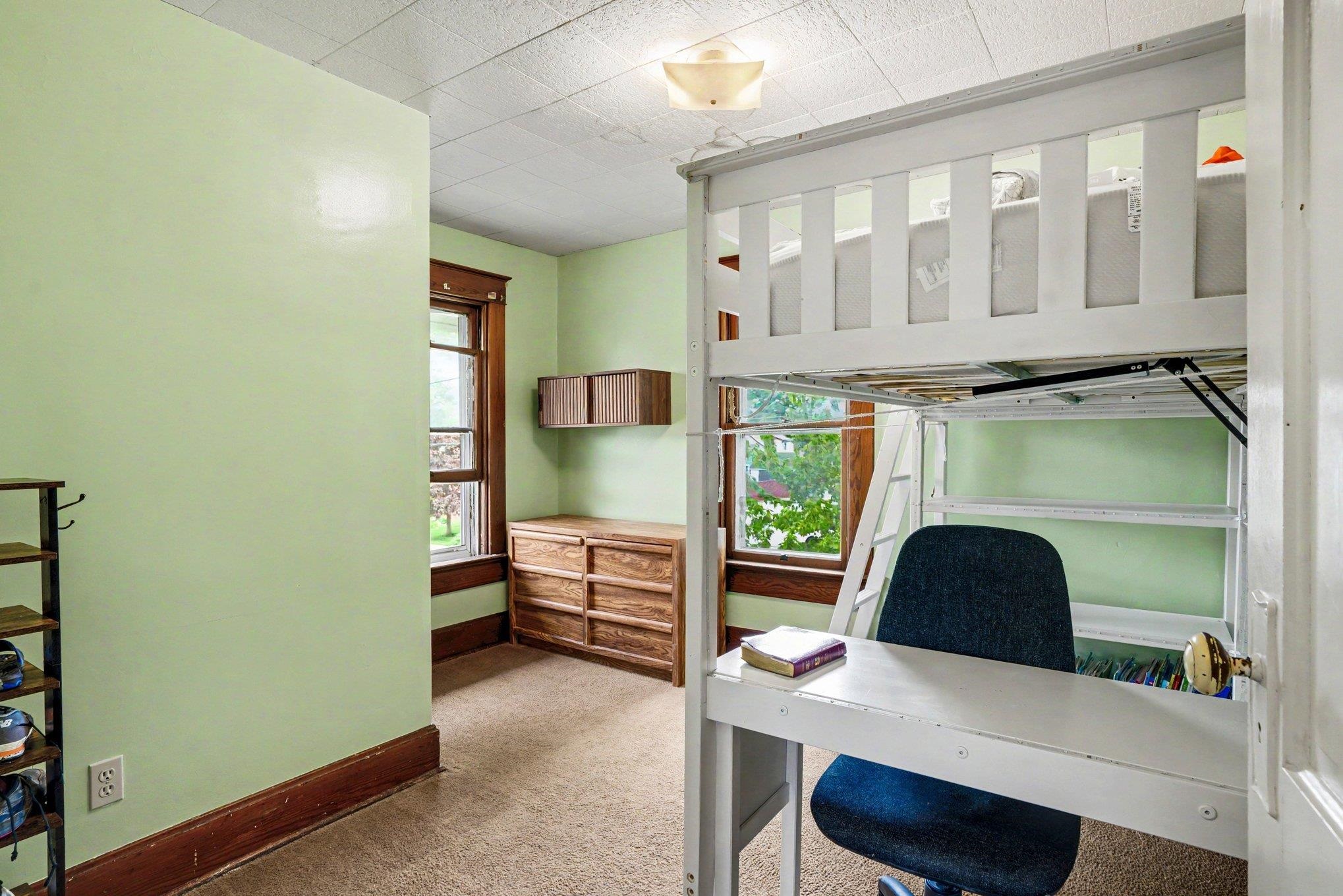 Room featuring light green walls, a single window with dark wood trim, and a textured ceiling