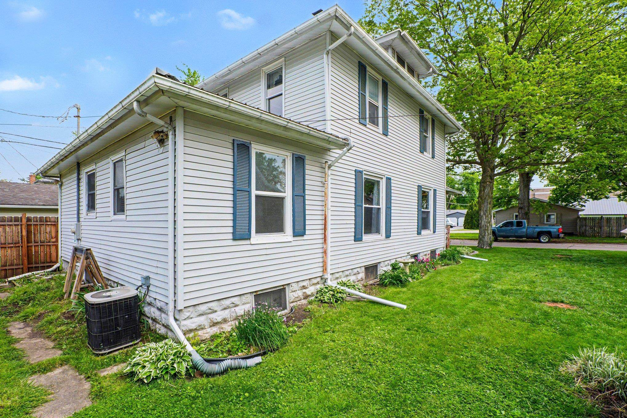 Two-story residence featuring white siding and blue window shutters