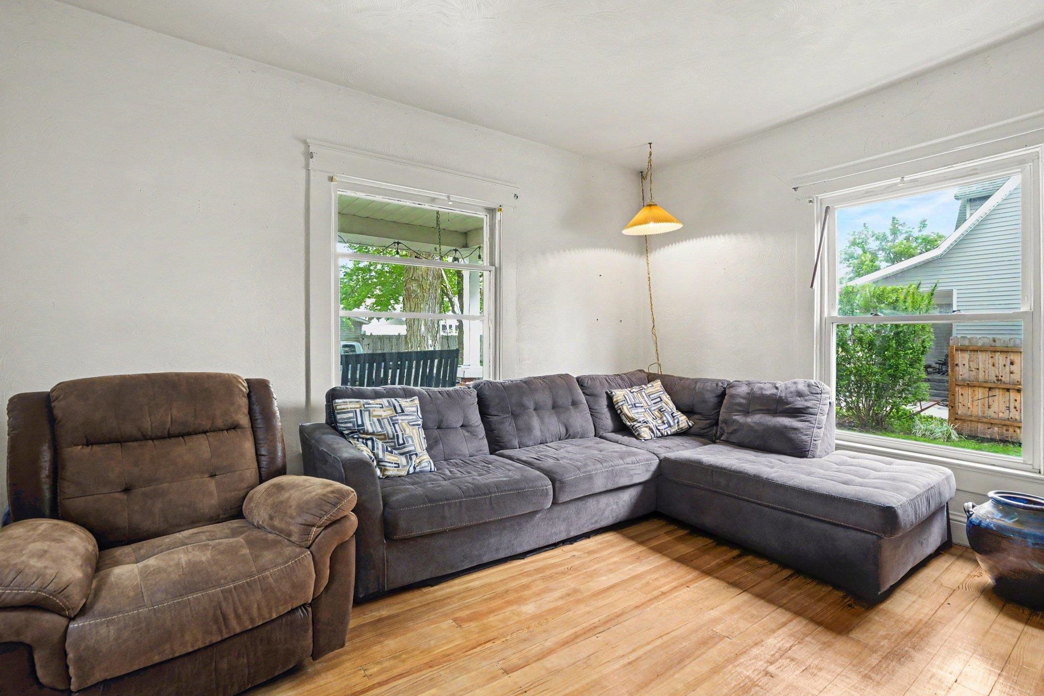 Room featuring natural wood-finish flooring, white walls, and white trim