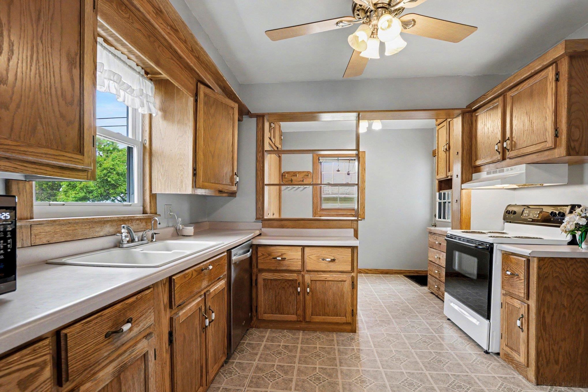 Kitchen featuring wood cabinetry, laminate countertops, and a ceiling fan with light fixture