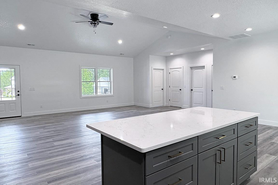 Kitchen island featuring a white countertop with gray cabinetry