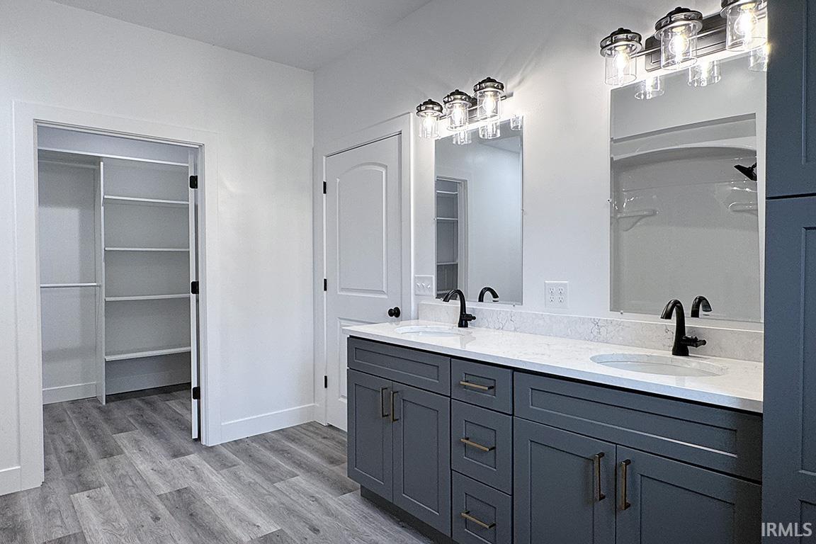 Dual vanity featuring gray cabinetry, integrated sinks, white countertops, and matte black fixtures