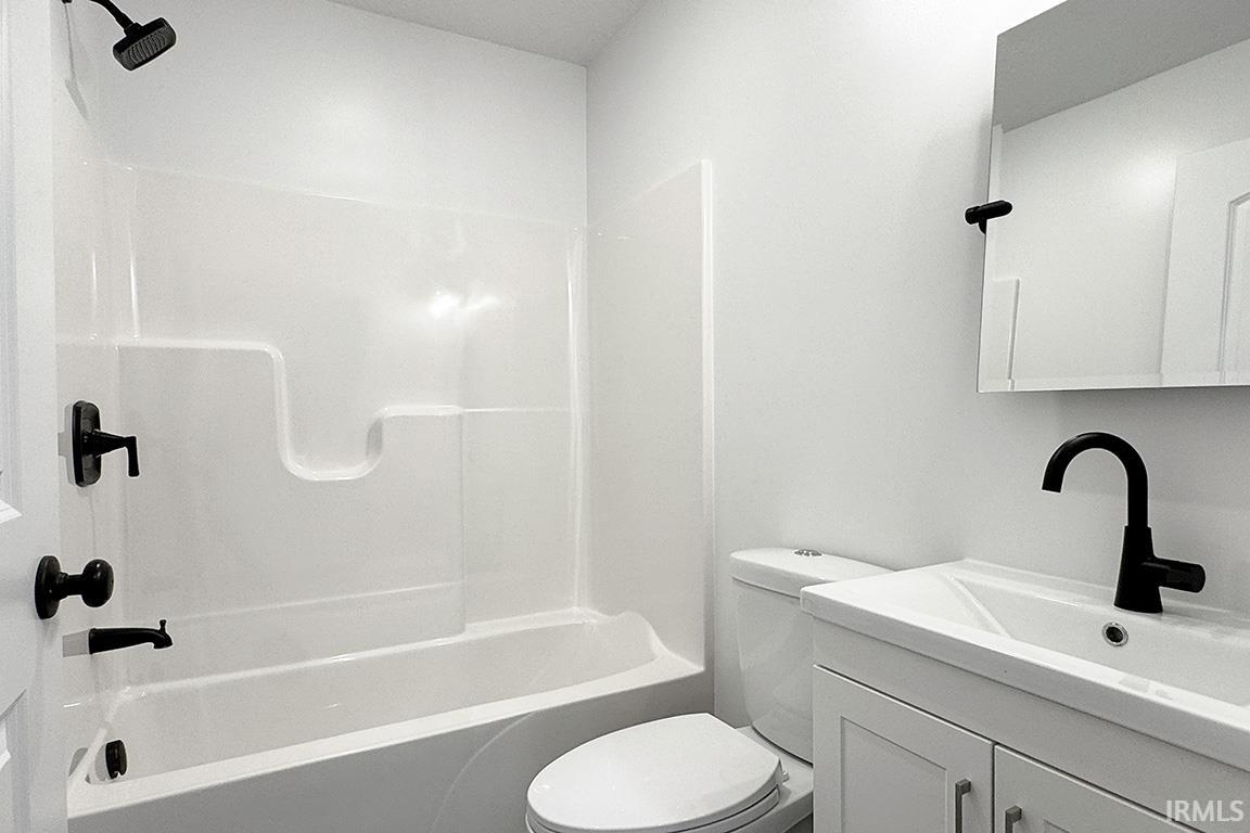 Bathroom featuring a white tub/shower combination with matte black fixtures, a white vanity with integrated sink, a matte black faucet, and a wall-mounted medicine cabinet
