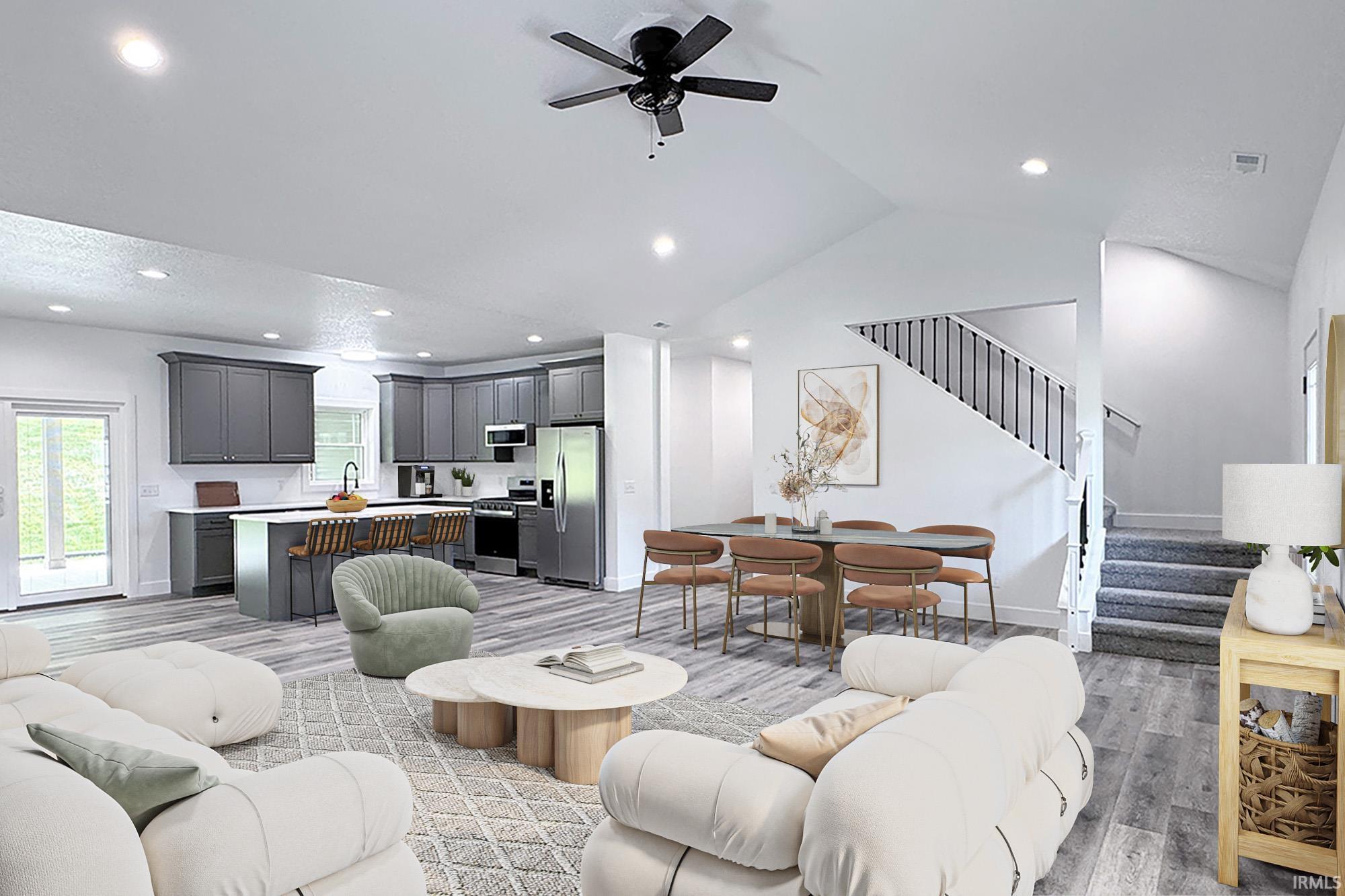 Open-concept living space featuring wood-finish flooring, recessed lighting, and vaulted ceilings