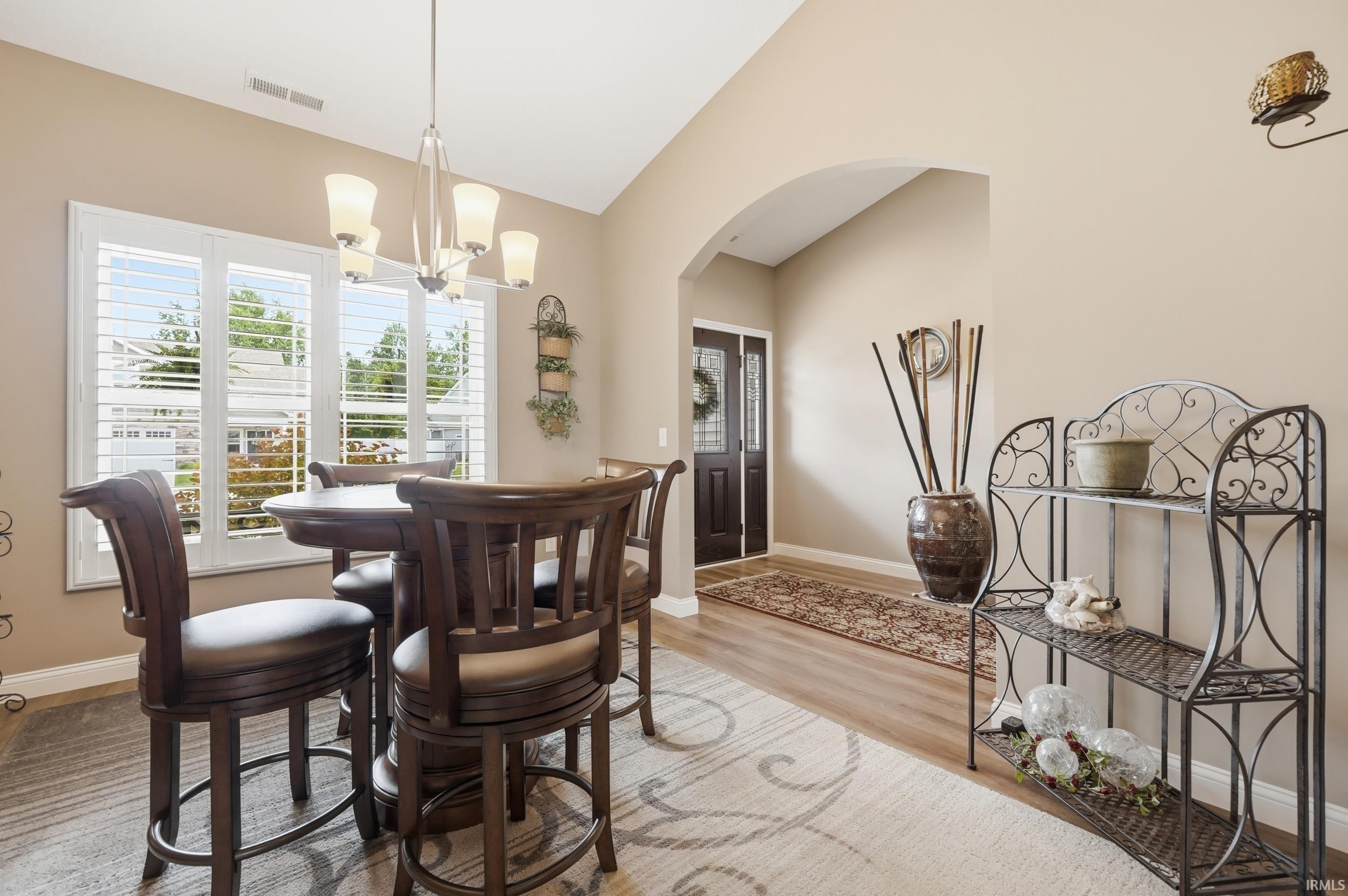 Dining area with vaulted ceiling and wood-finish flooring