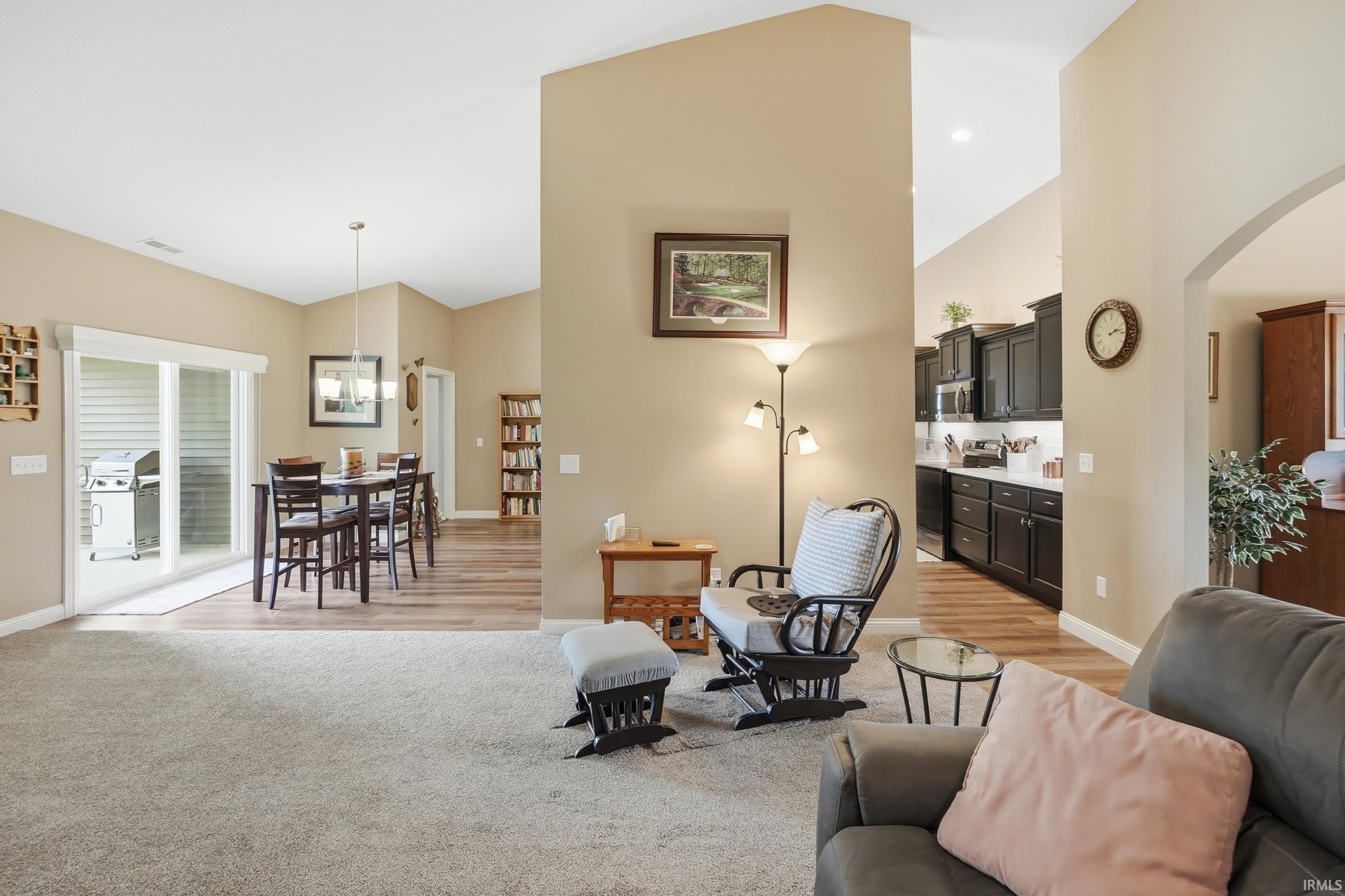 Vaulted ceilings enhance this living space with neutral wall tones and plush carpeting