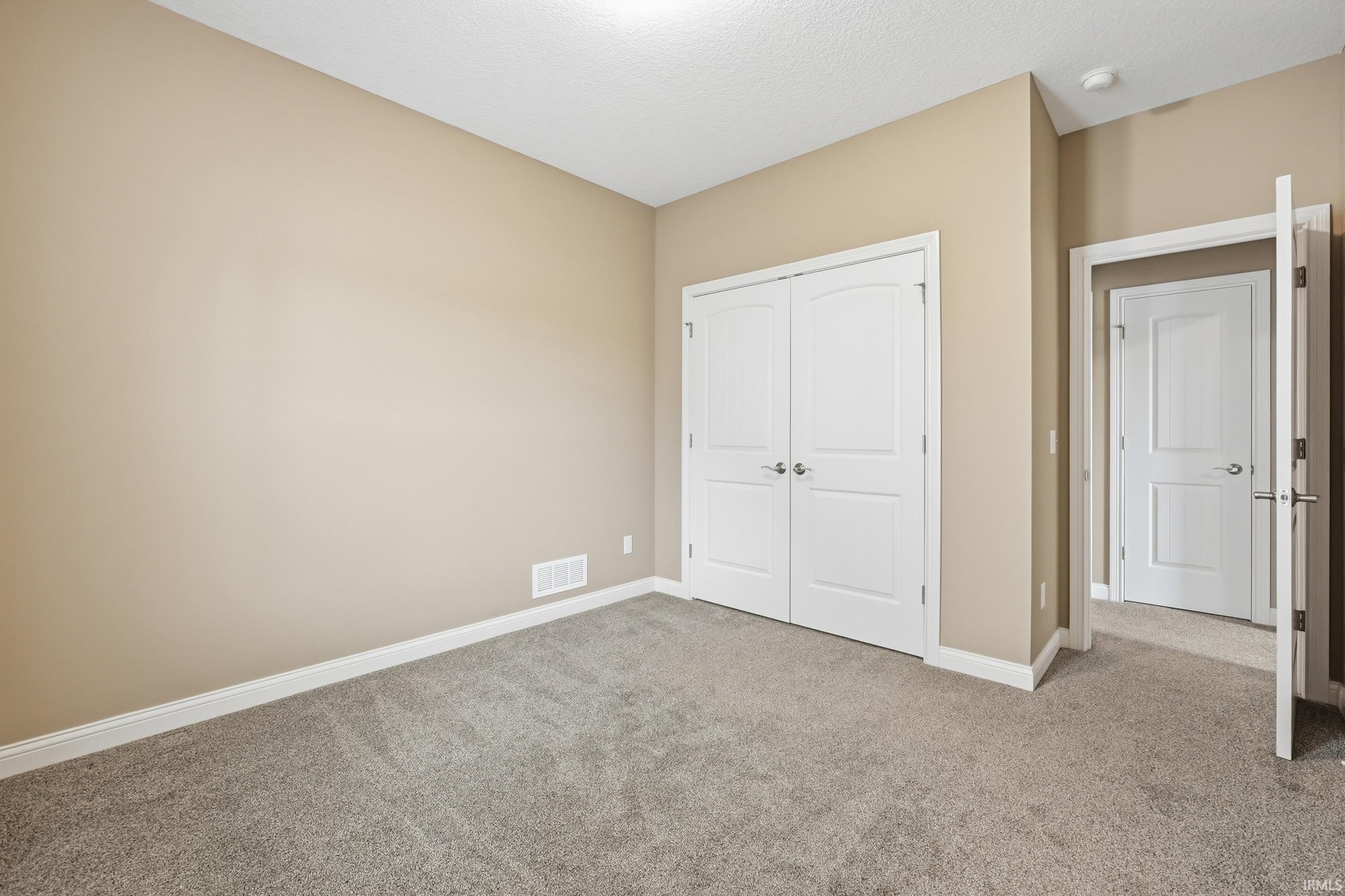 Neutral-toned walls complement the gray carpeting