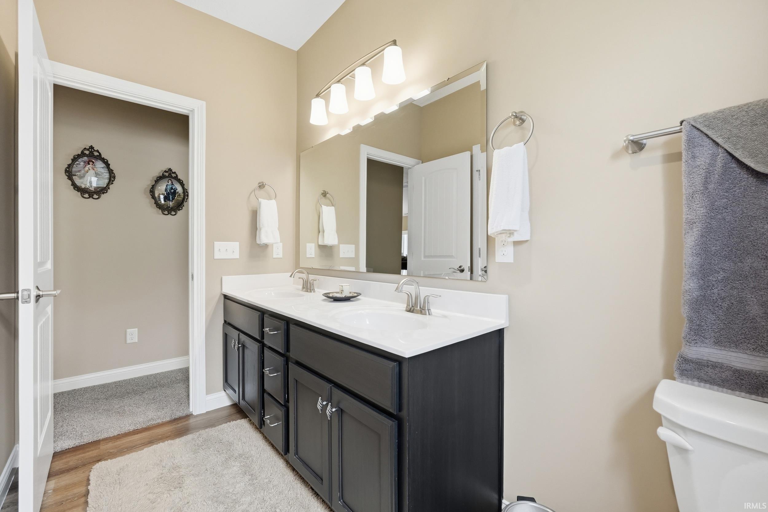 Double vanity with a white countertop and dark cabinetry, featuring dual sinks and contemporary brushed nickel faucets