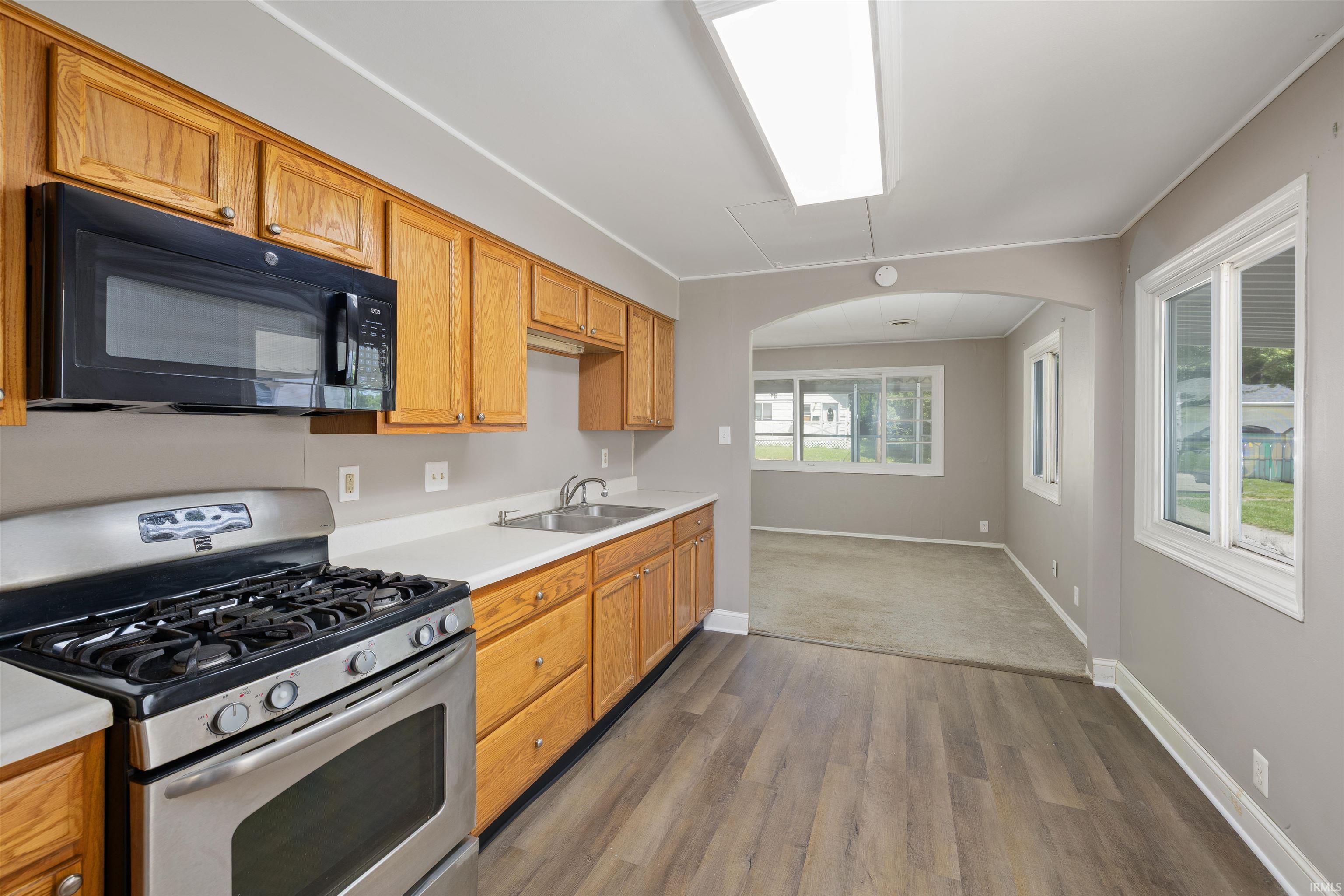 Kitchen featuring wood cabinetry, stainless steel range, and an over-the-range microwave