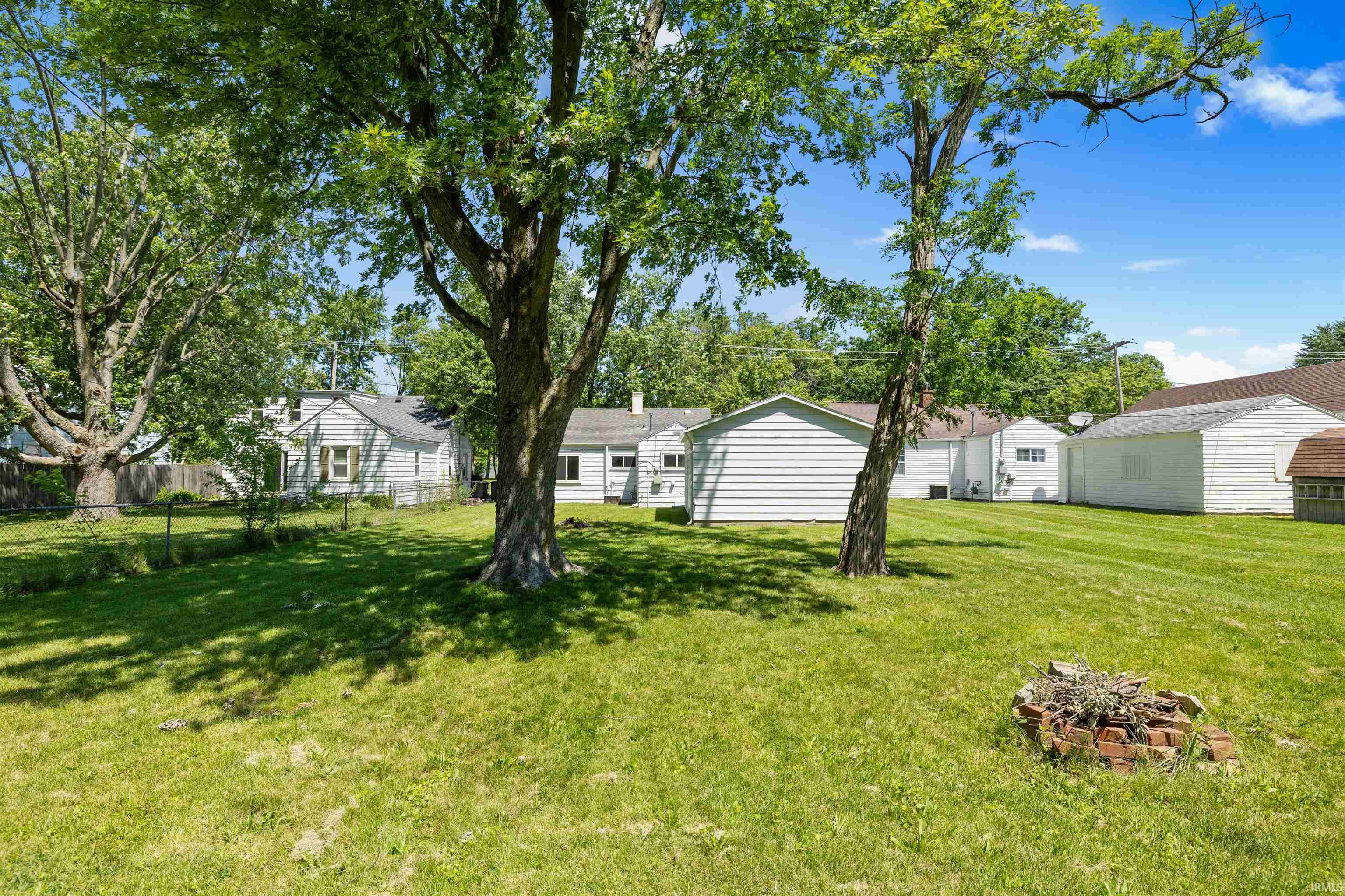 Expansive green lawn featuring mature trees
