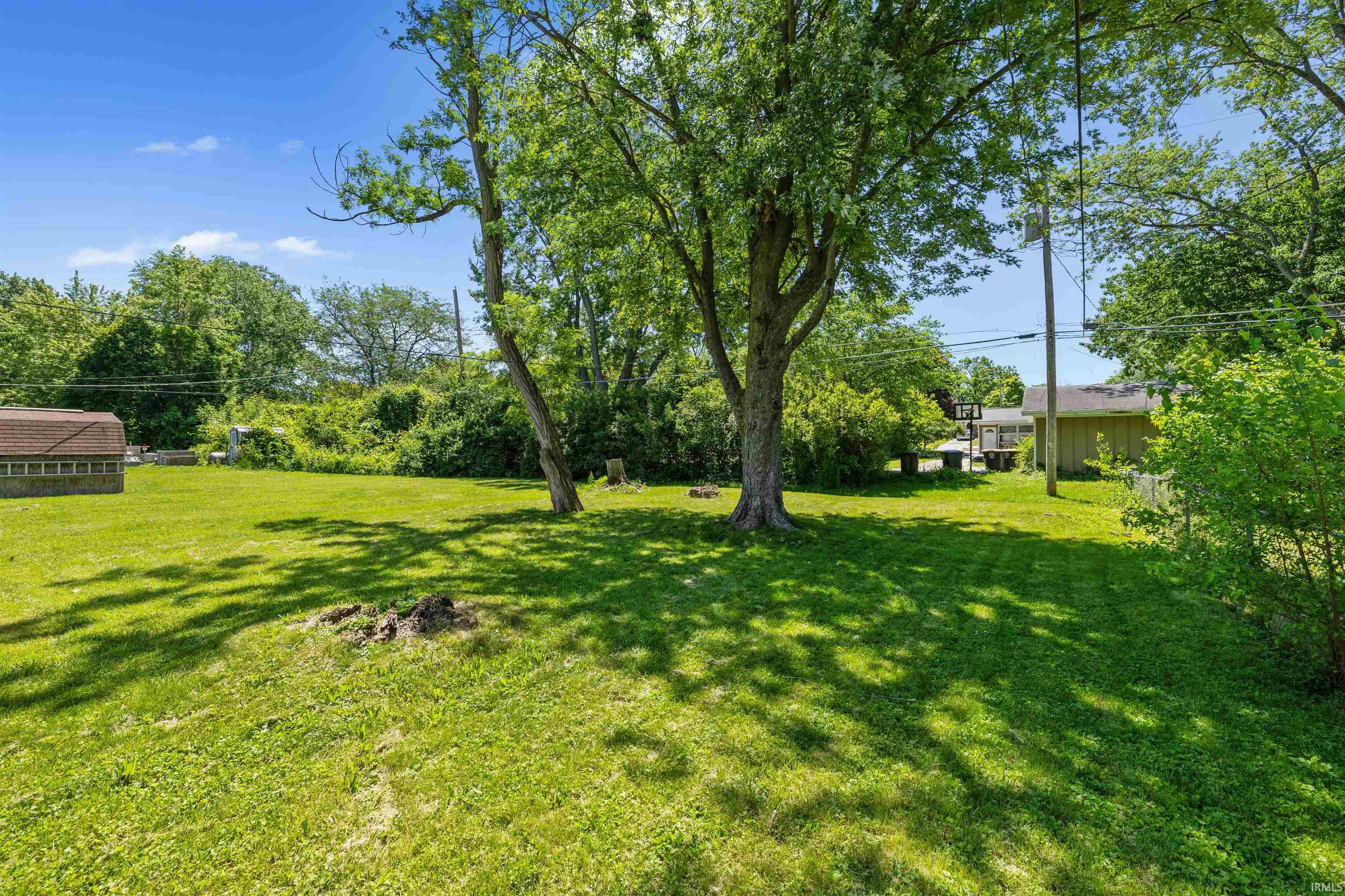 Expansive, level green space featuring mature trees and a manicured lawn