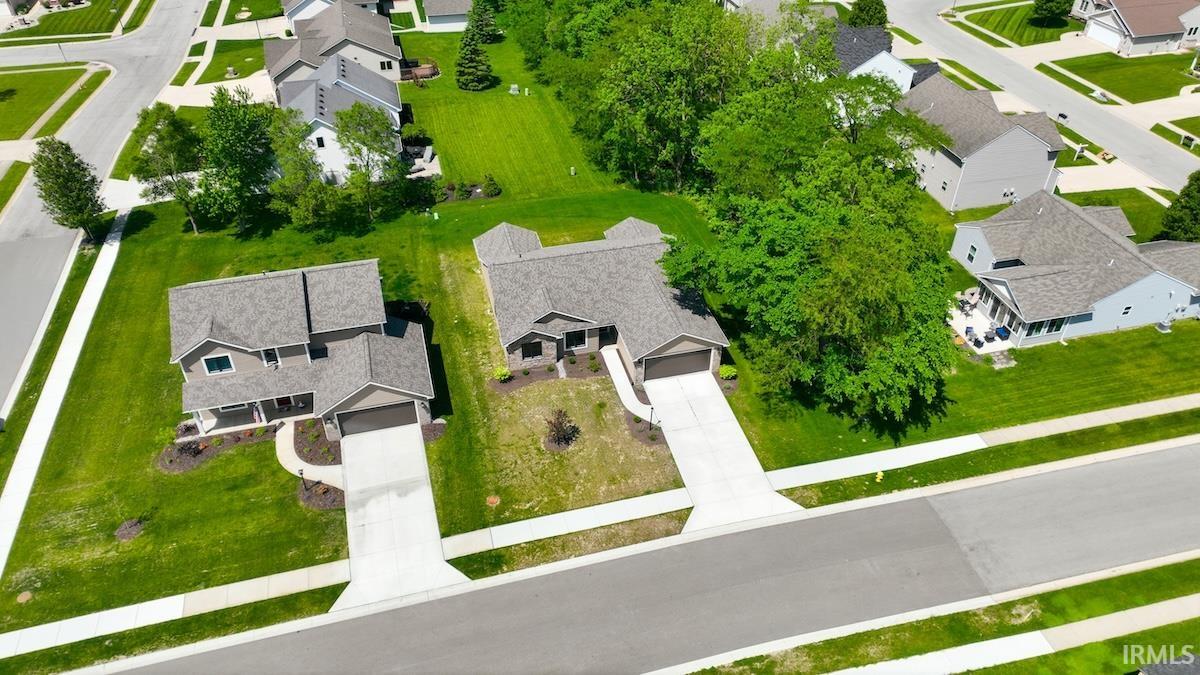 Contemporary two-story residence with an attached garage, light gray siding, and a covered porch