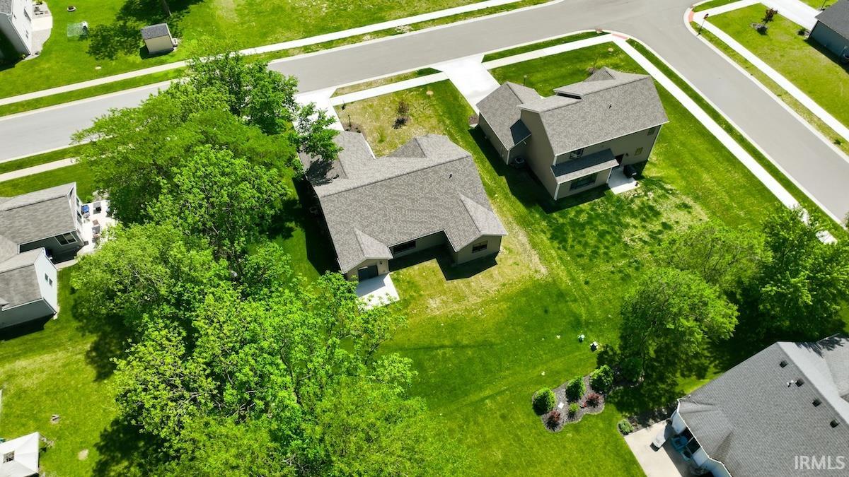 Expansive property featuring a corner lot, mature trees, manicured lawns, paved streets, and concrete sidewalks