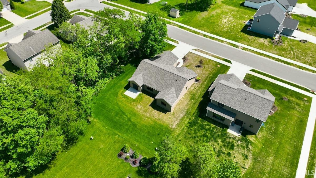 Aerial perspective showcasing a residential property with a shingled roof and light-colored siding