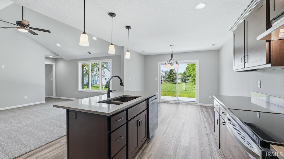 Kitchen island with dual basin sink, quartz countertop, and pendant lighting