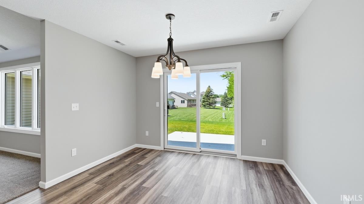 Dining area featuring wood-finish flooring and a contemporary chandelier