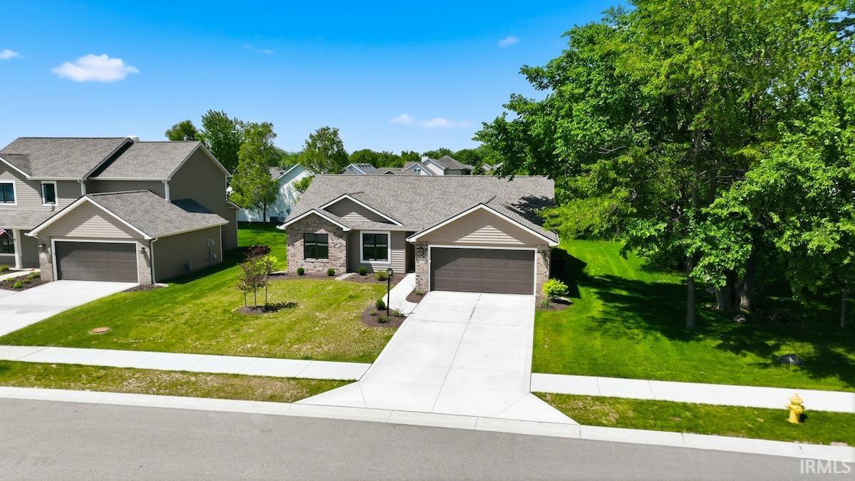 Ranch-style residence featuring a brick and siding exterior, an attached two-car garage, and a concrete driveway