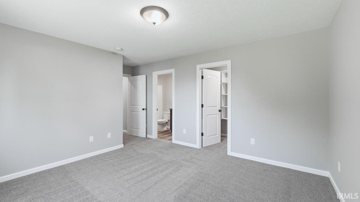 Carpeted room with light gray walls, white trim, and a semi-flush mount ceiling light
