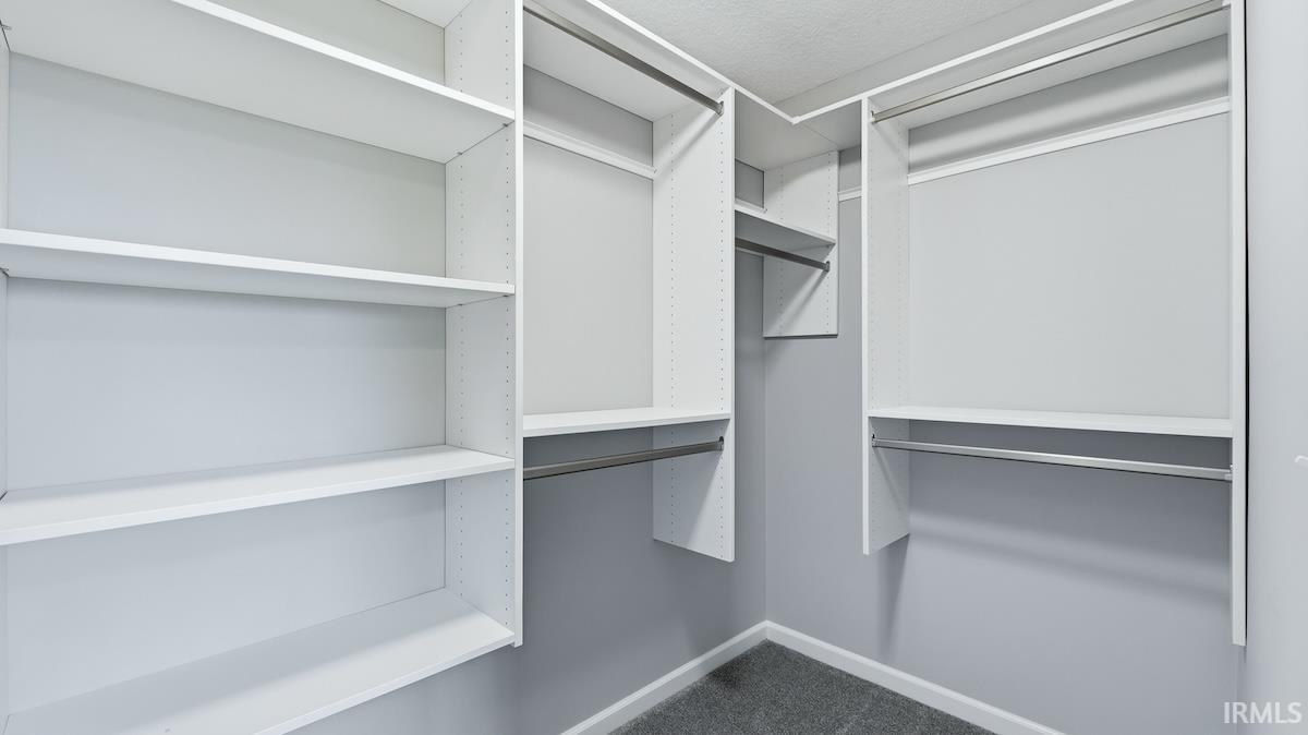 Custom closet system featuring white shelving and chrome hanging rods