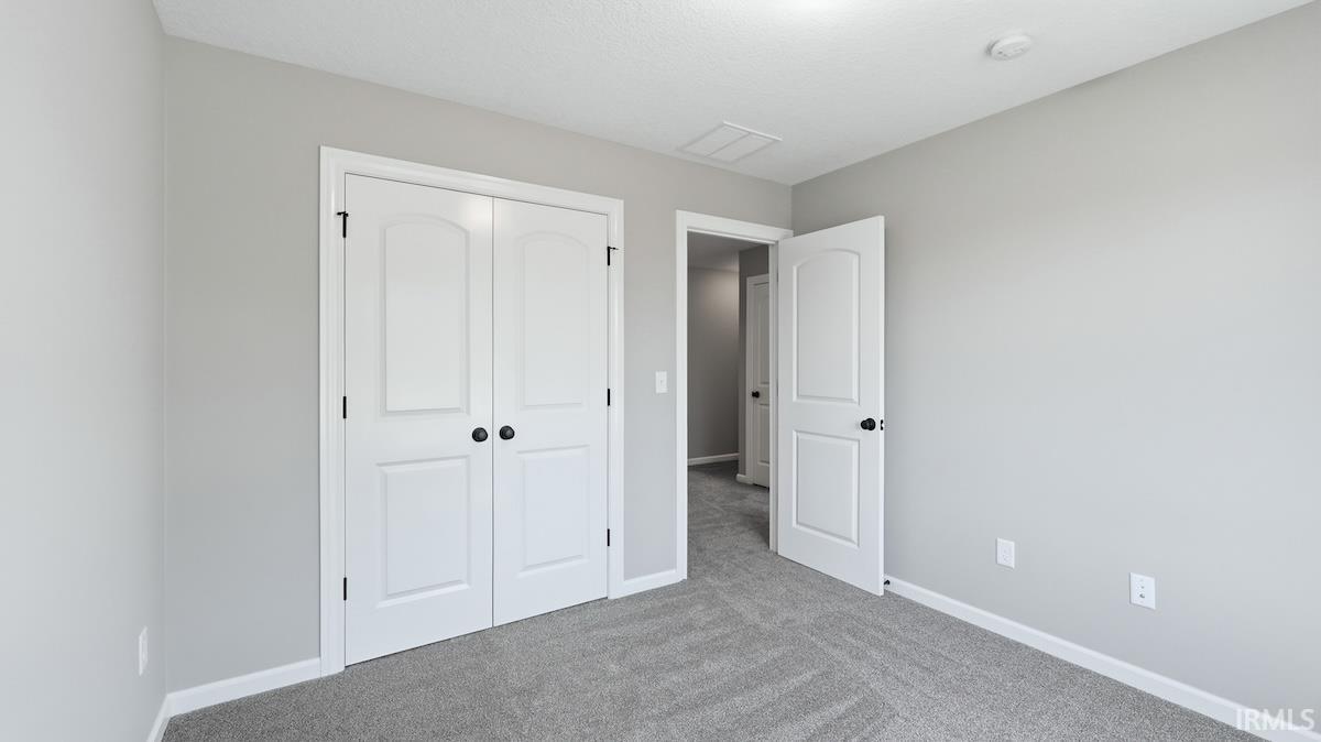 Neutral-toned interior featuring grey carpeting and white baseboards
