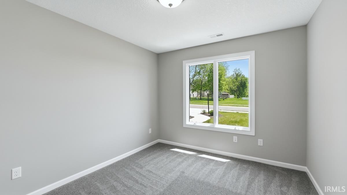 Room featuring light gray walls and gray patterned carpet