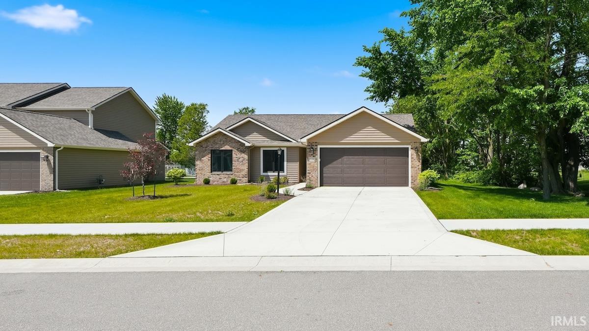 Single-story residence featuring brick and siding exterior, an attached two-car garage, and a concrete driveway