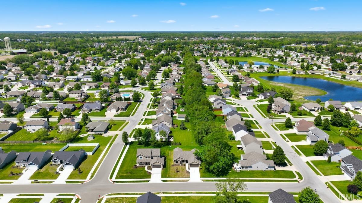 Aerial perspective showcasing a residential development with structured streets, manicured lawns, and a consistent architectural style