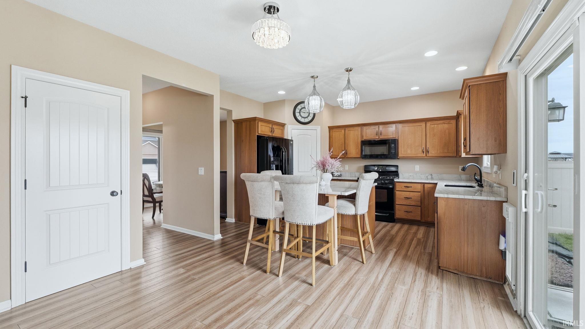 Kitchen featuring wood-finish flooring, light-toned cabinetry, light-toned countertops, and recessed lighting