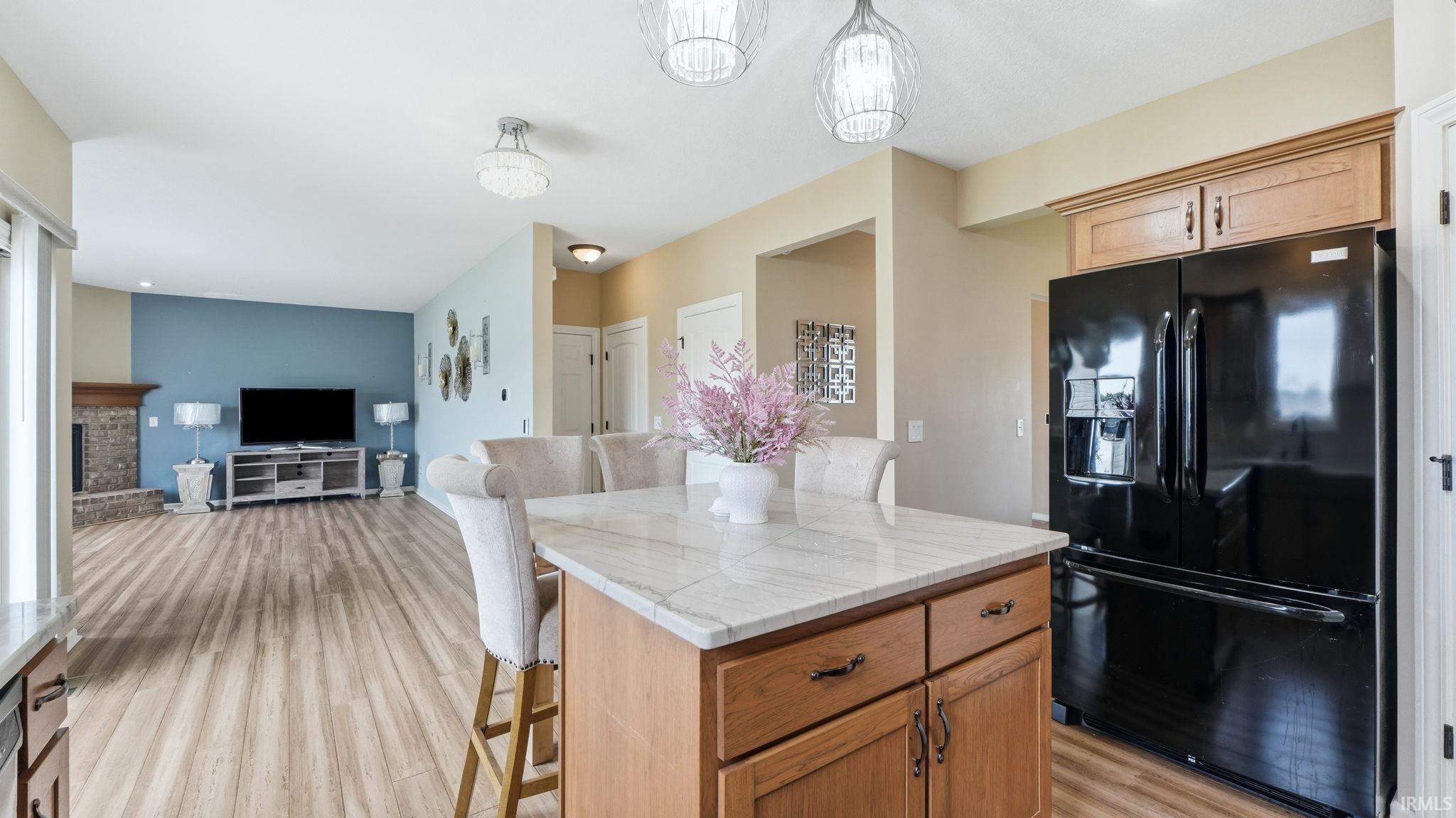 Kitchen island featuring a light-toned countertop, wood cabinetry, and integrated seating