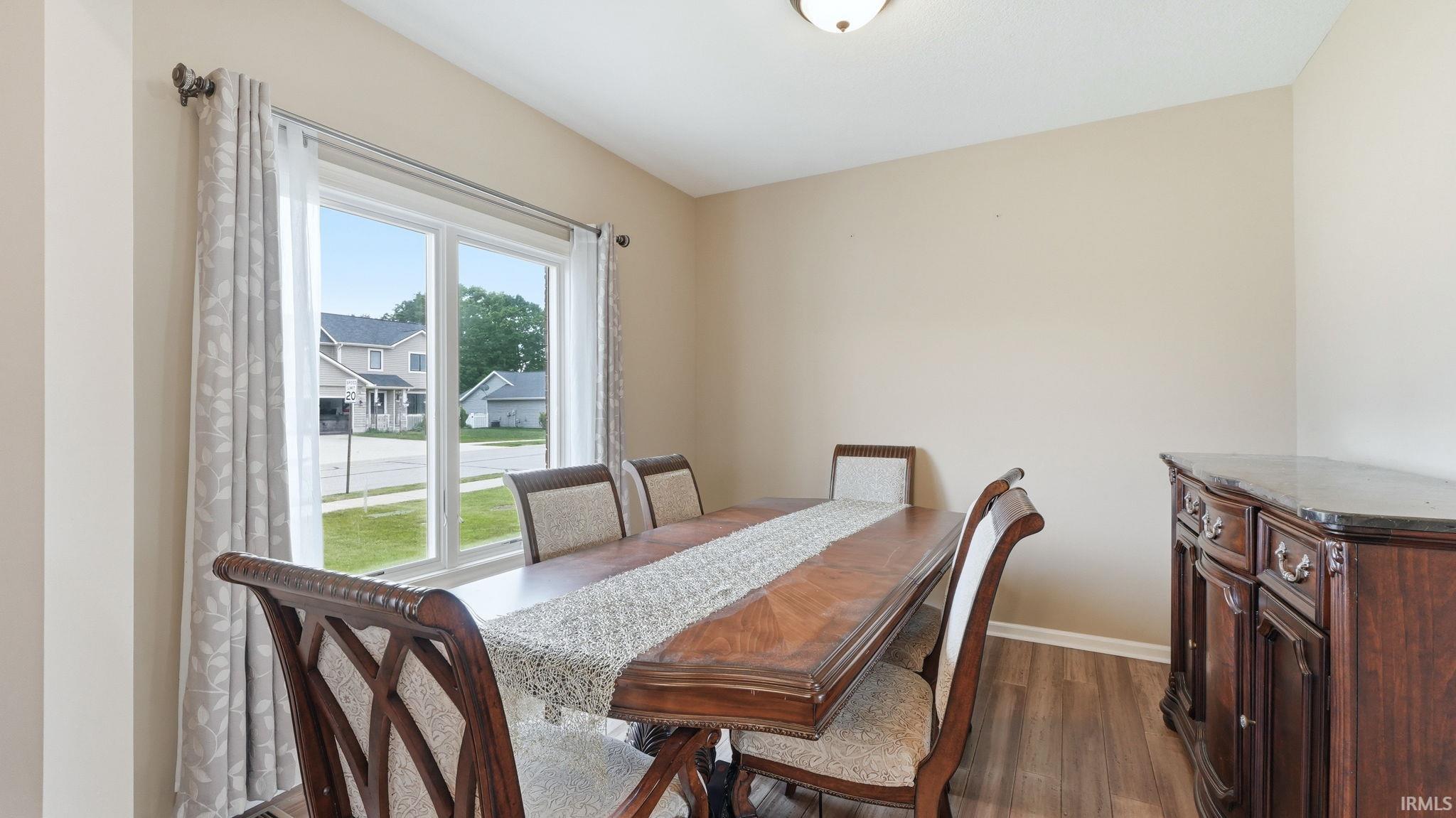 Dining area featuring a large window, wood-finish flooring, and neutral wall paint