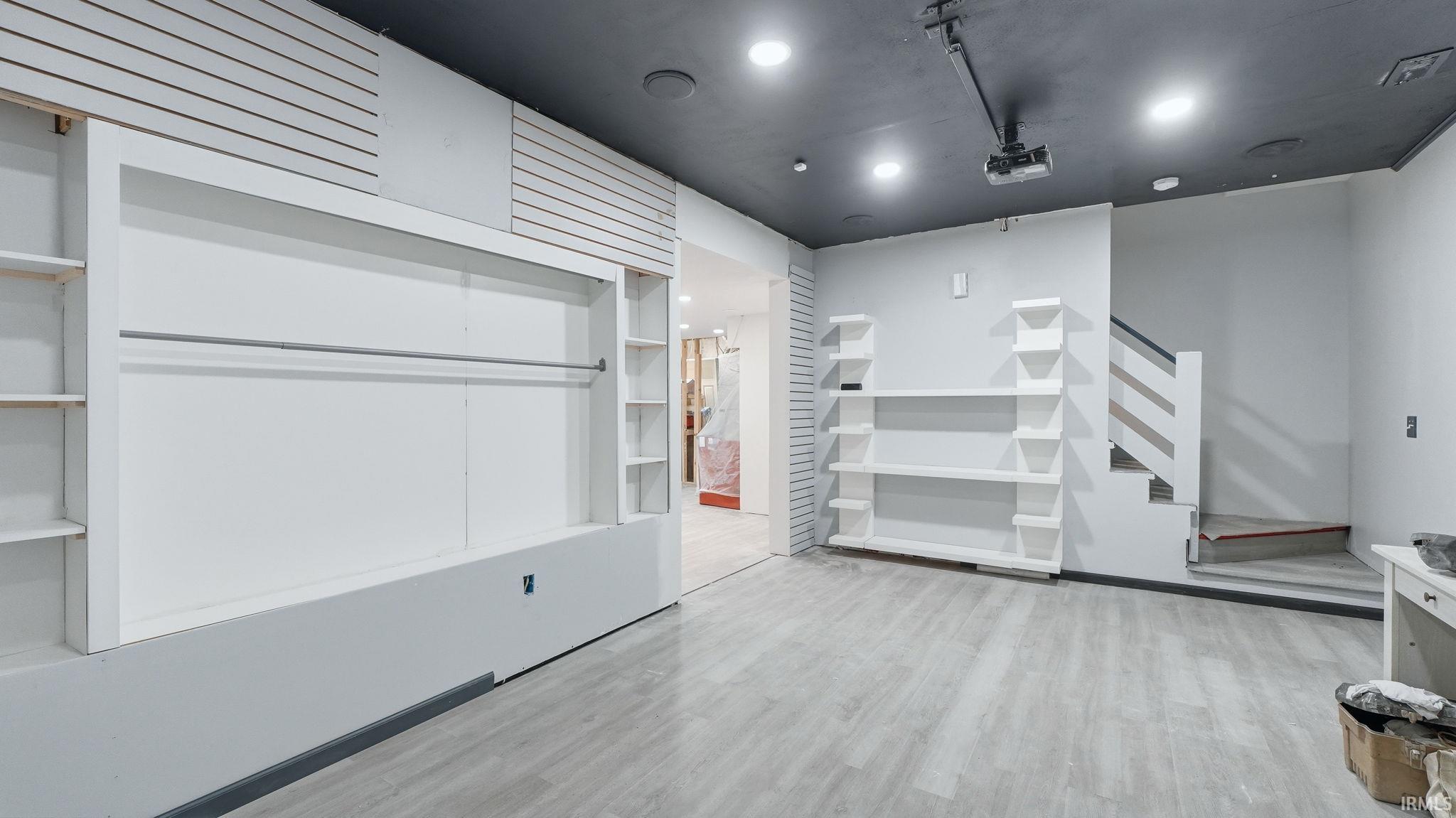 Spacious commercial interior featuring contemporary wood-finish flooring, recessed lighting, and a dark ceiling