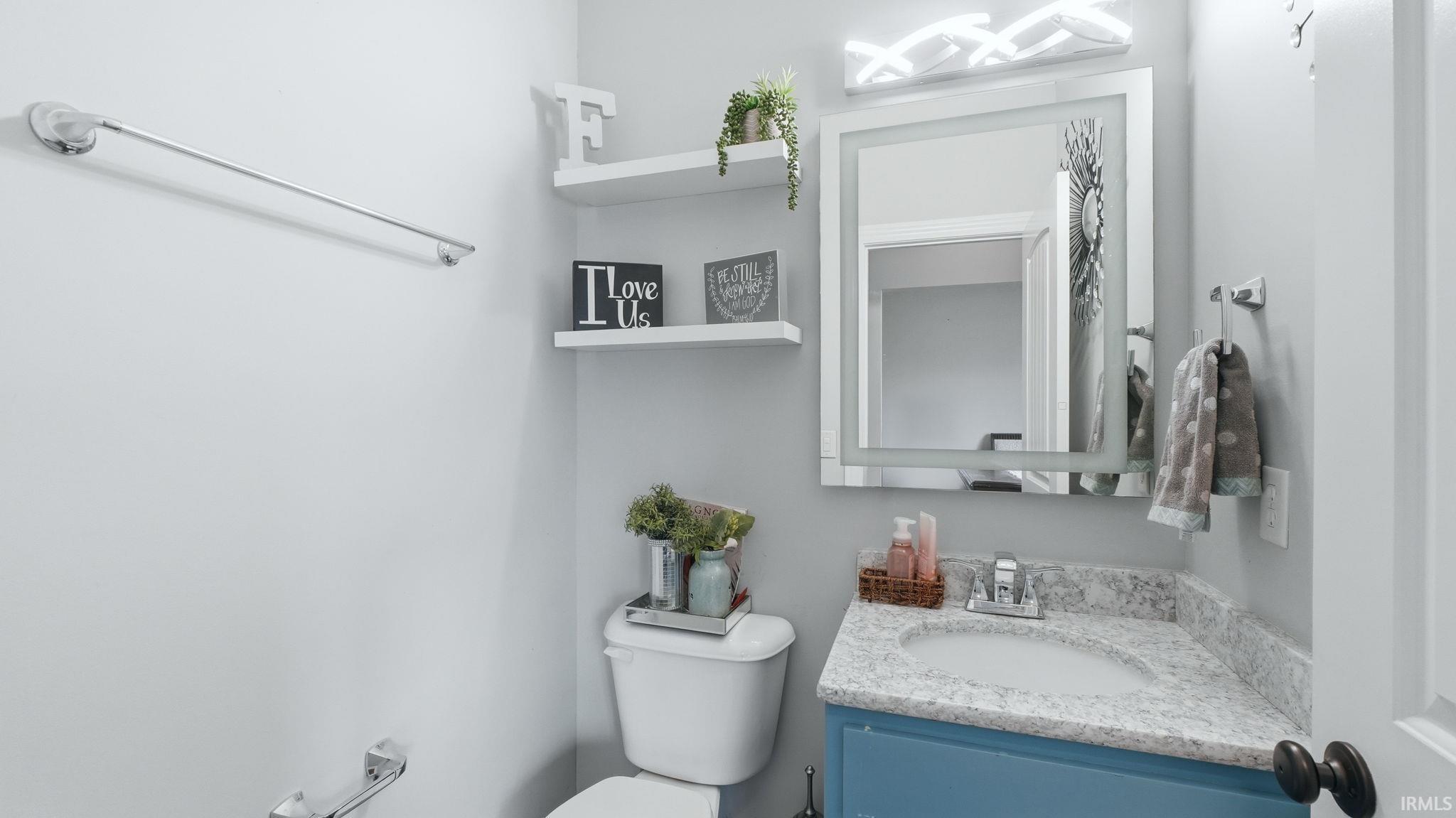 Bathroom vanity featuring a light-colored countertop, undermount sink, and a blue base cabinet