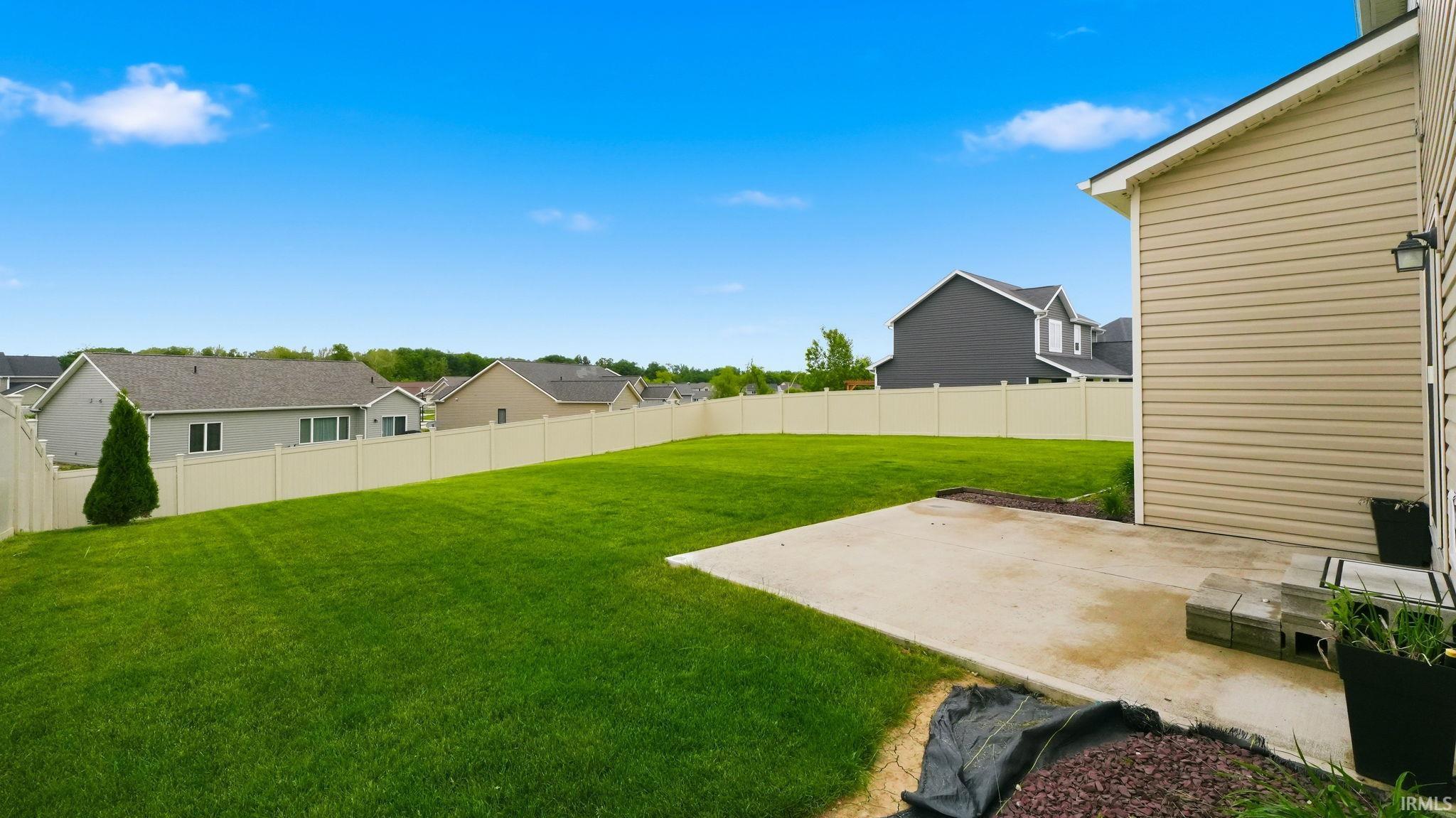 Expansive green lawn with a full privacy fence