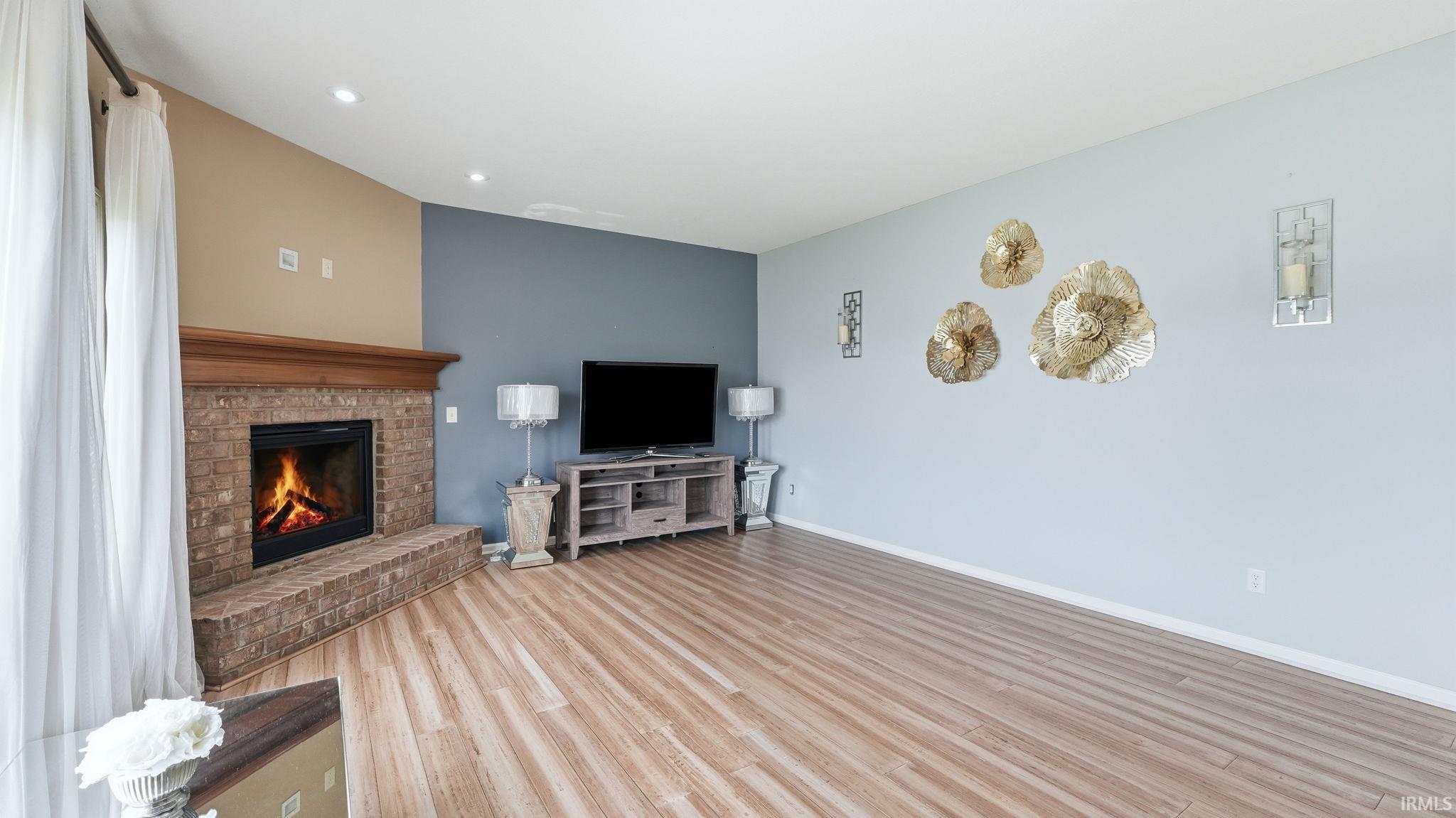 Corner fireplace with brick surround and wood mantle