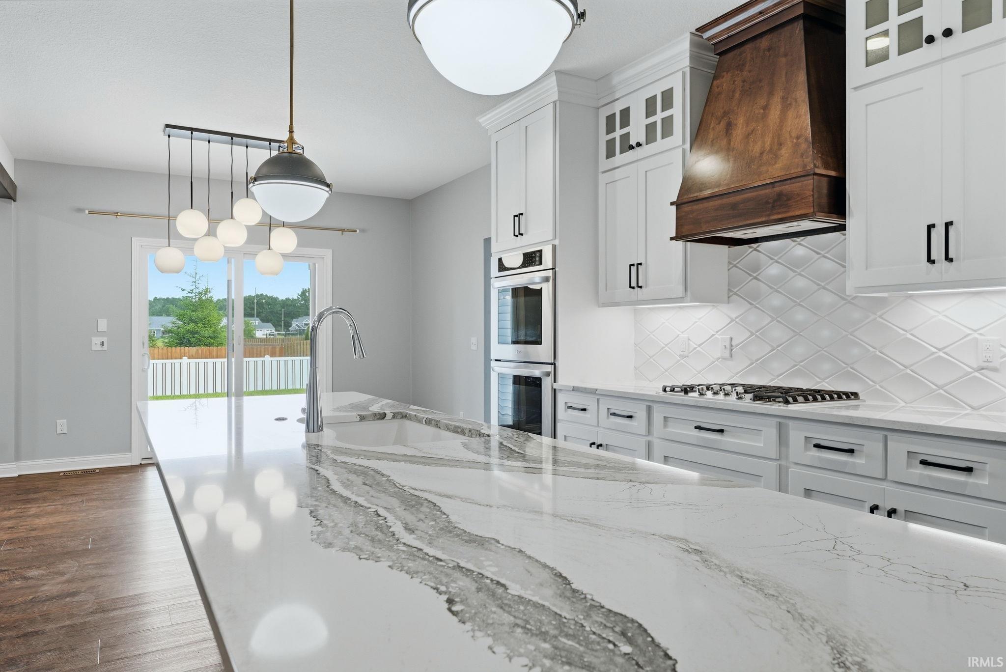 Kitchen featuring a large central island with an integrated sink and gooseneck faucet