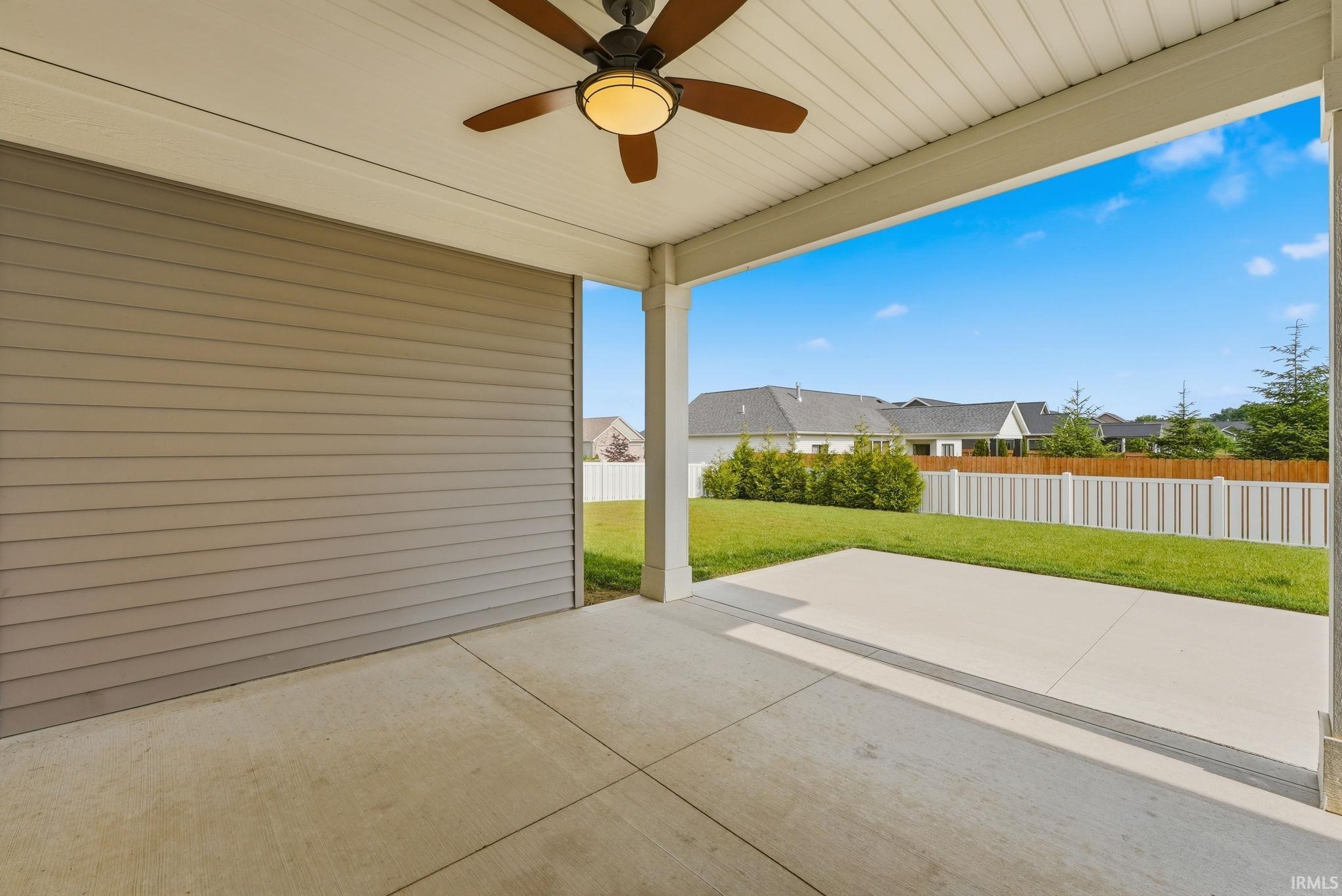 Covered patio featuring a ceiling fan with integrated lighting, concrete flooring, and horizontal siding