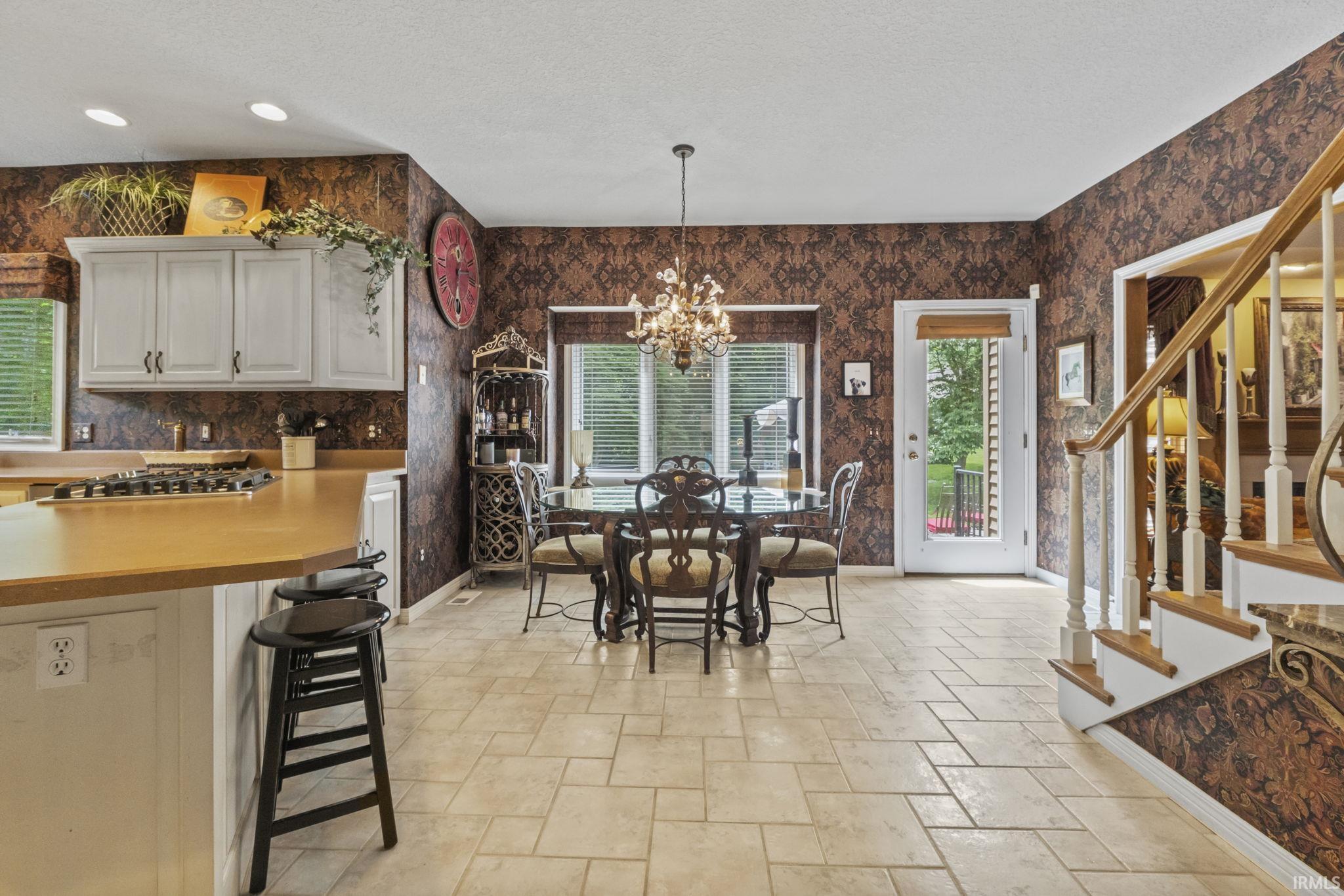 Kitchen and dining area featuring light-toned tile flooring throughout