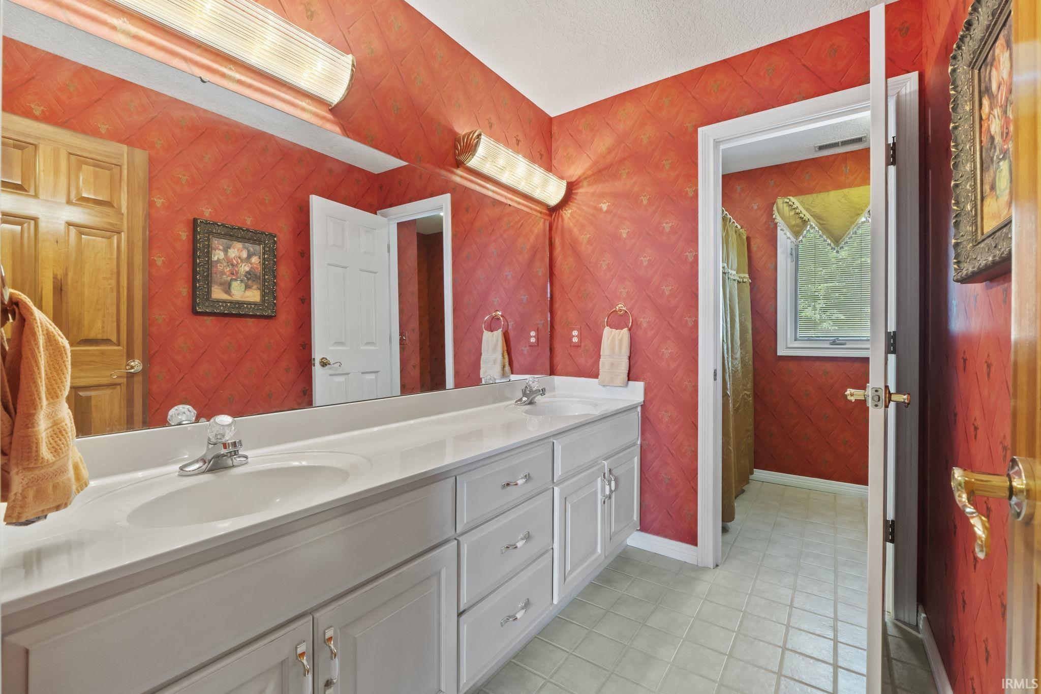 Double vanity with integrated sinks, white countertops, and light gray cabinetry