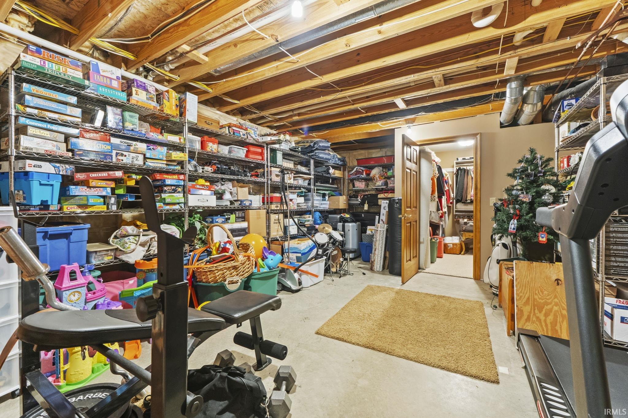 Unfinished basement featuring exposed wood ceiling joists and concrete flooring