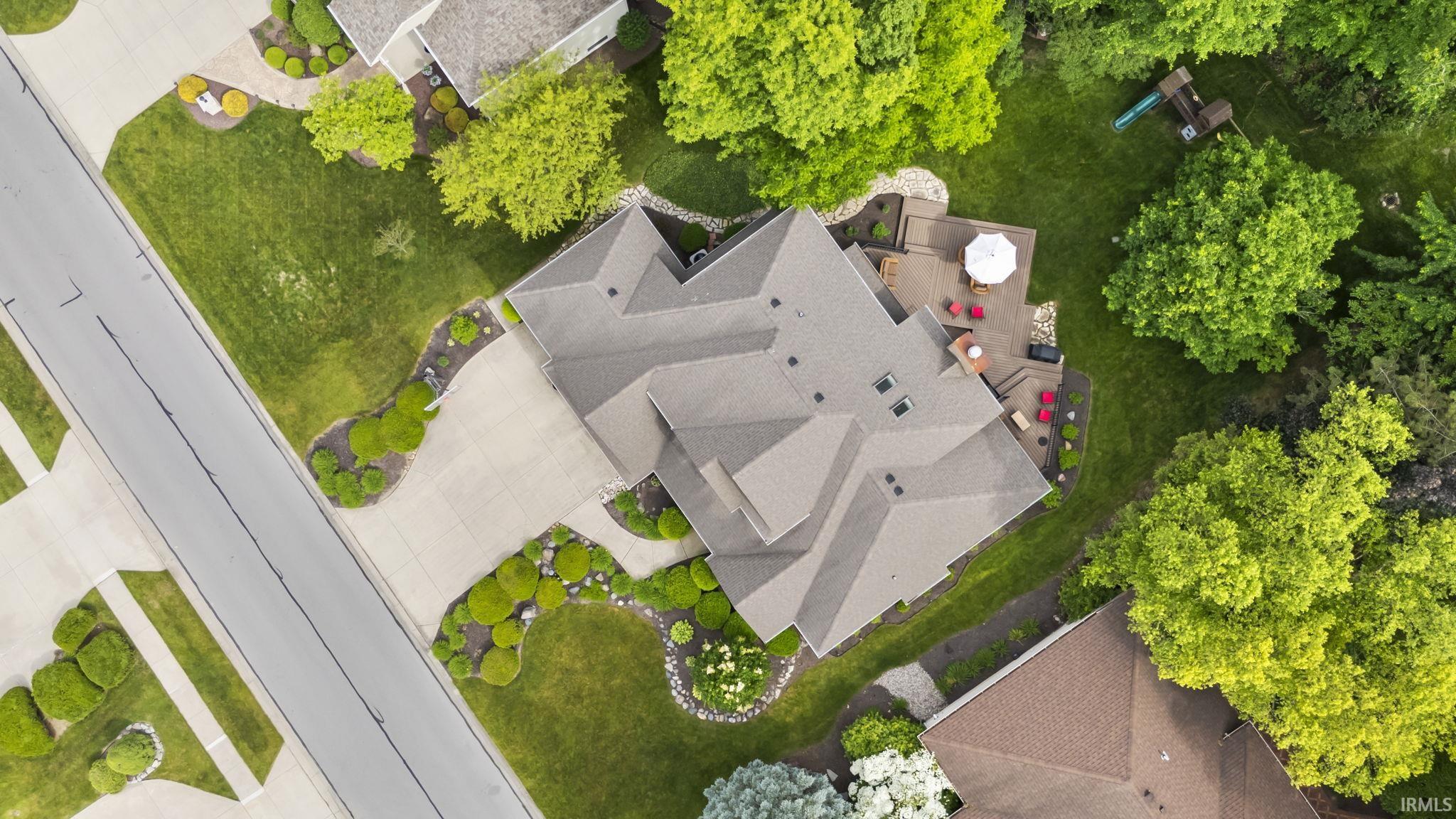 Aerial perspective showcasing a multi-gabled roofline and an expansive rear deck