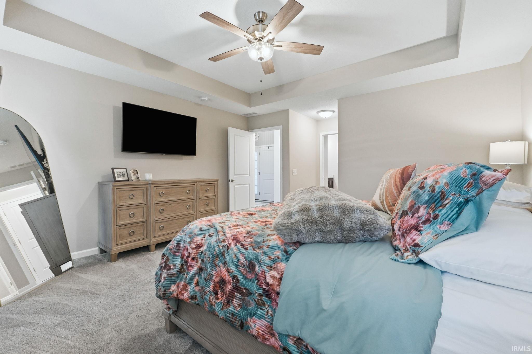 Bedroom featuring tray ceiling, recessed lighting, ceiling fan with light kit, and light gray carpeting