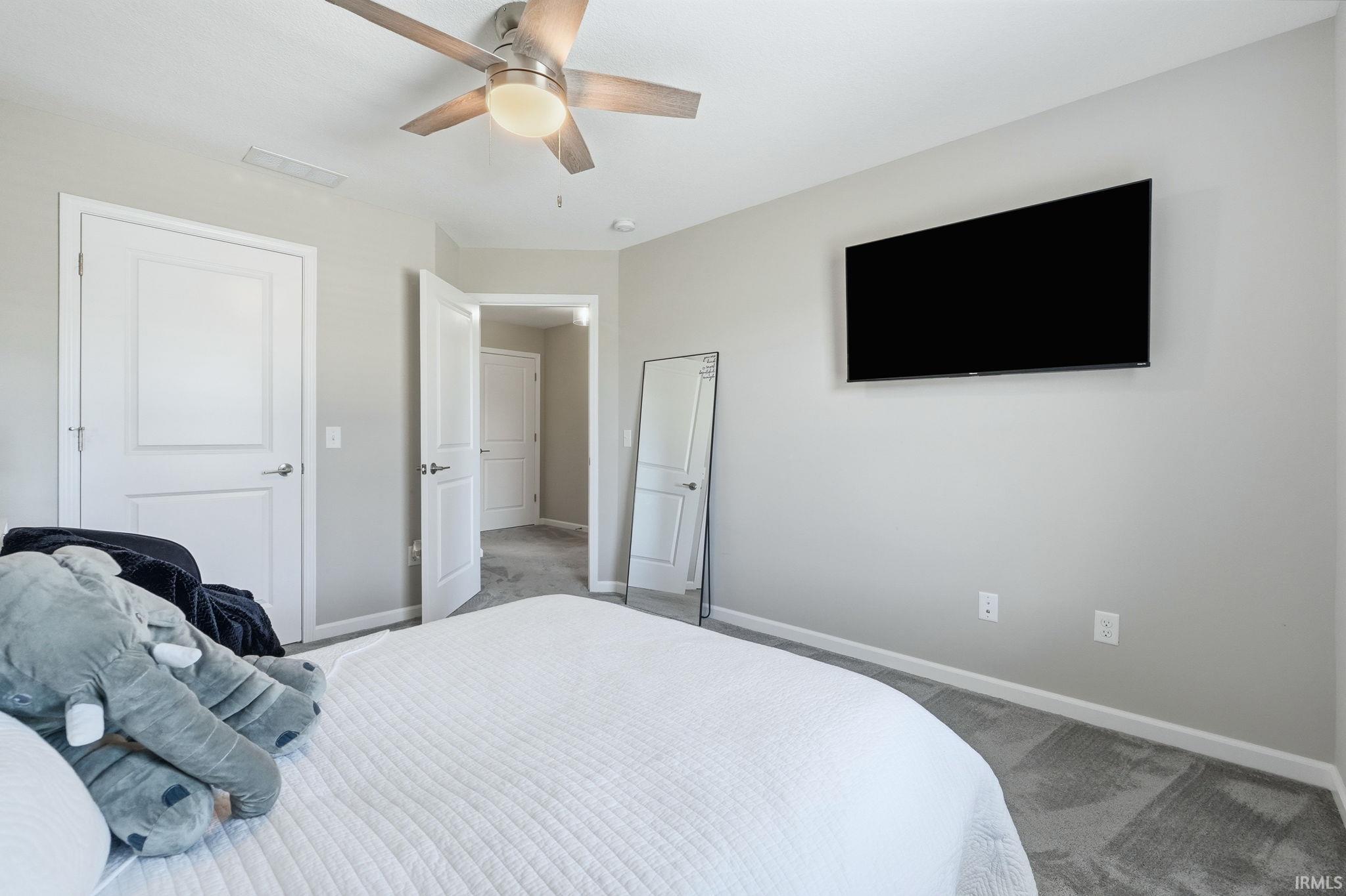 Carpeted interior space featuring light gray walls and white trim