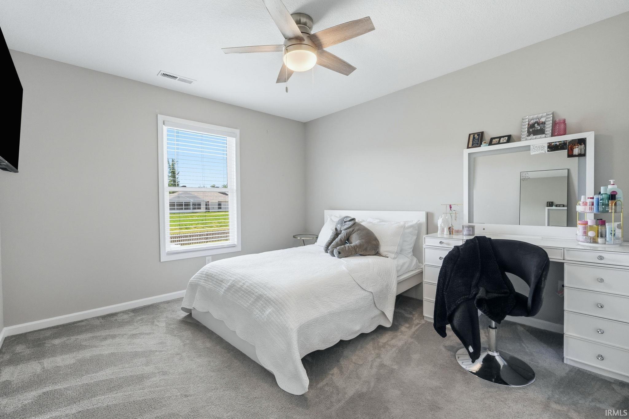 Spacious room featuring neutral gray walls and coordinating carpet flooring