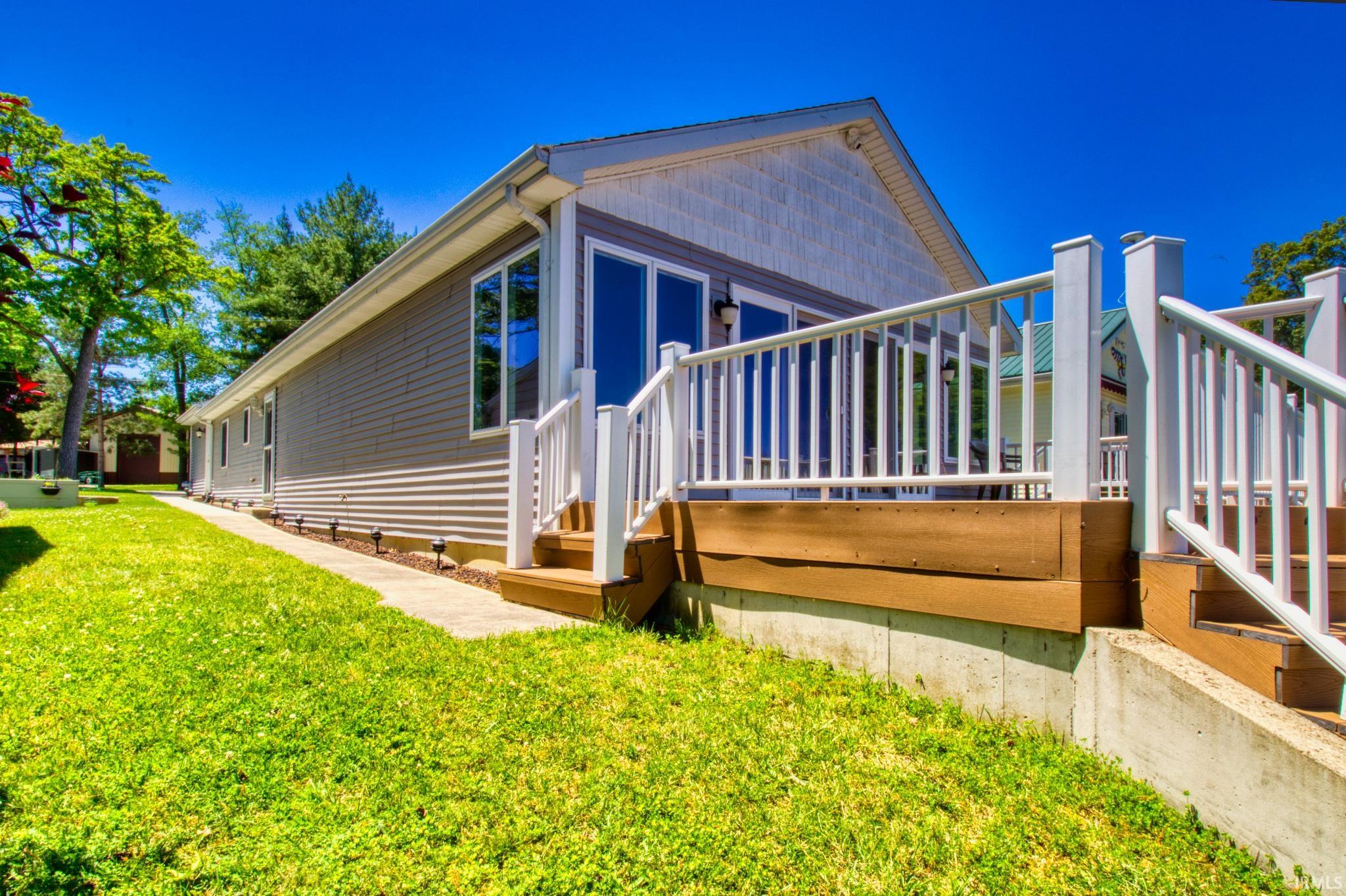 Exterior siding in a neutral gray, with white trim and a white shingle-style gable