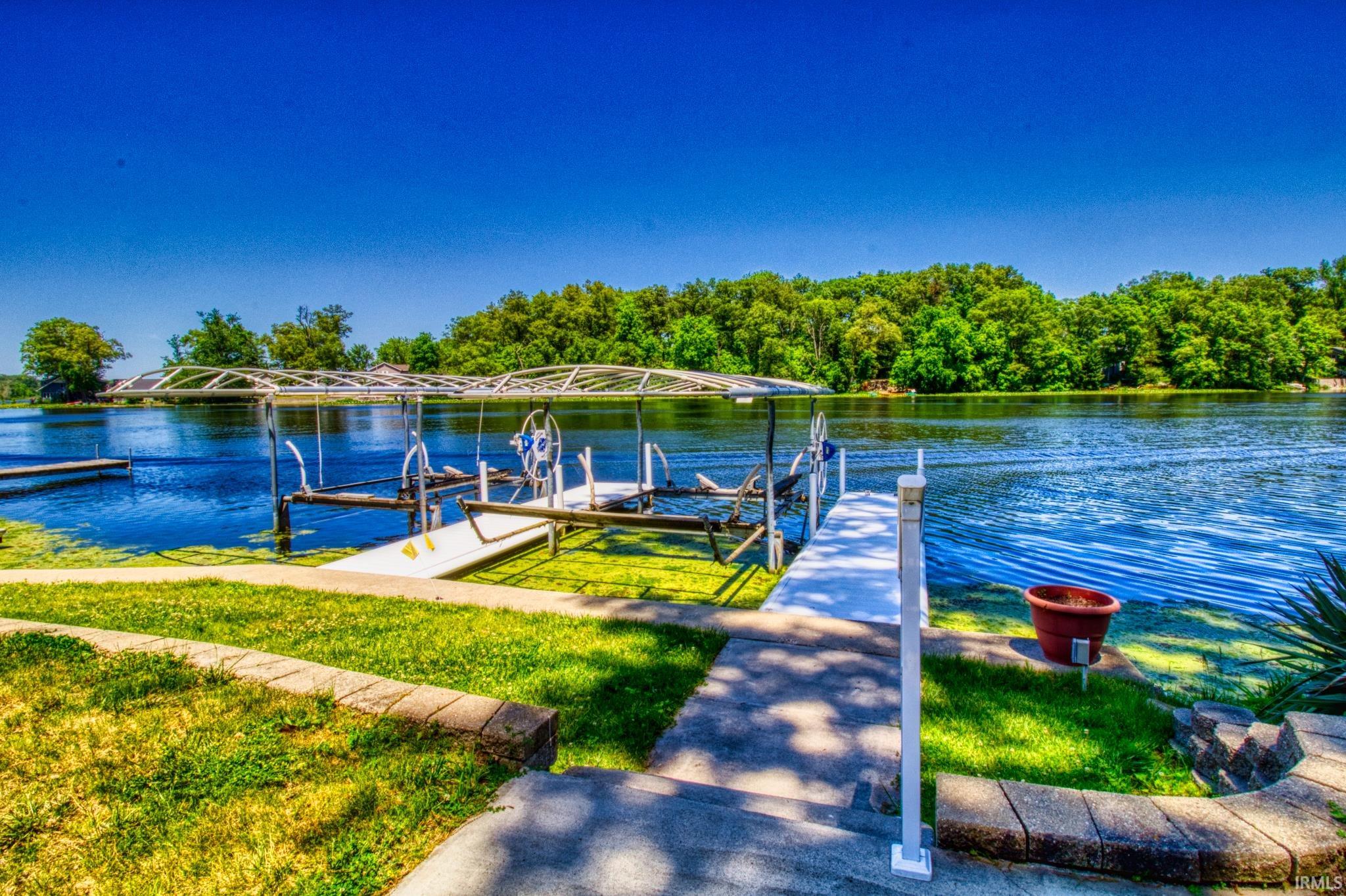 Waterfront property featuring a private dock with an integrated boat lift and a separate pier