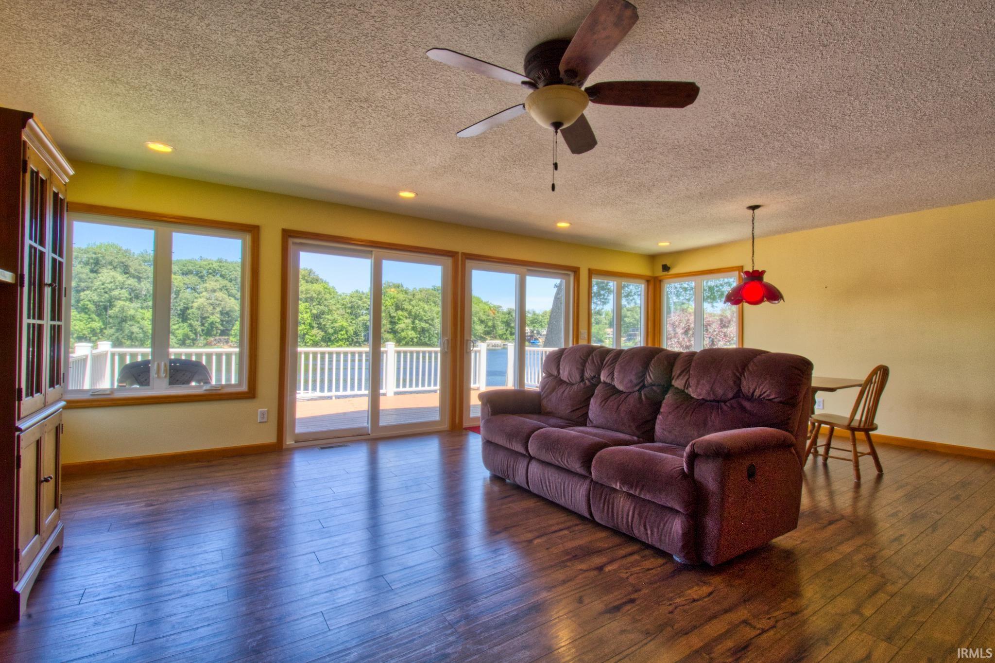 Spacious living area featuring wood-finish flooring, recessed lighting, and a ceiling fan